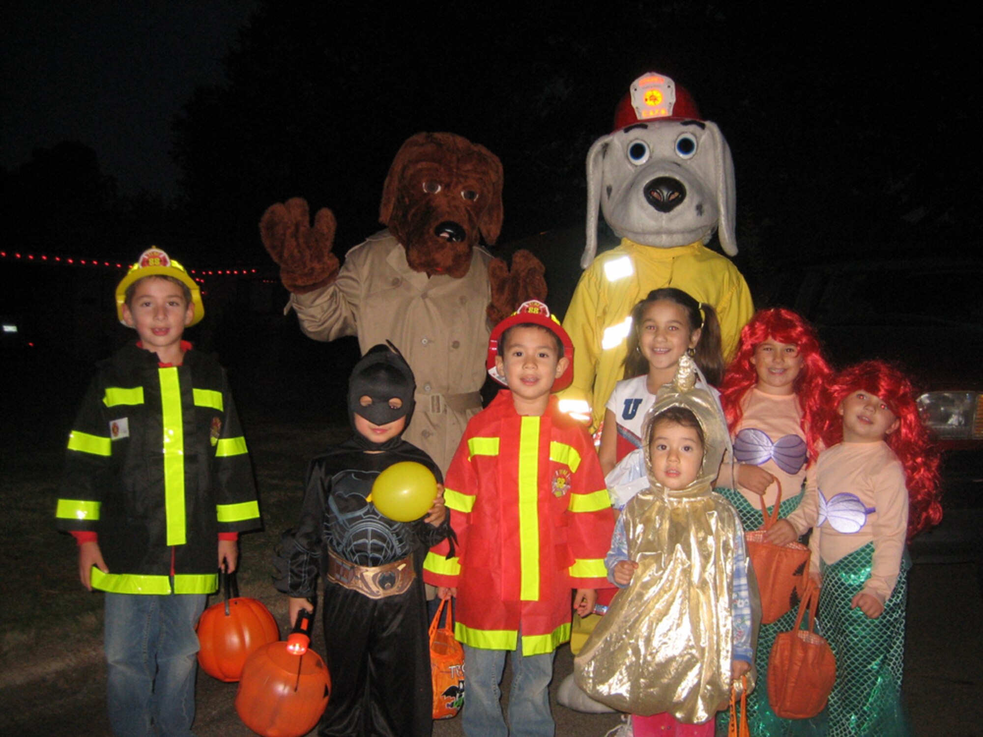 Sparky and McGruff pose with youth during Pumpkin Patrol Oct. 31 at Columbus AFB. The two greeted base youth in base housing. (U.S. Air Force photo by 2nd Lt. Justin VanPatten)
