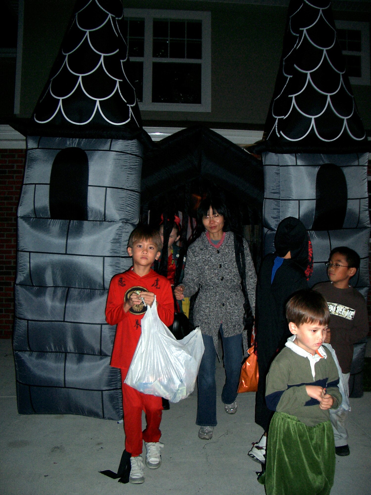 A family exits an Eagle Heights 'haunted garage' Wednesday.  Amn. Steven Chergosky, 436th Aerial Port Squadron, and his wife Fawn, converted their garage into a haunted scene for base trick-or-treaters to enjoy. (U.S. Air Force photo/Tech. Sgt. Kevin Wallace)