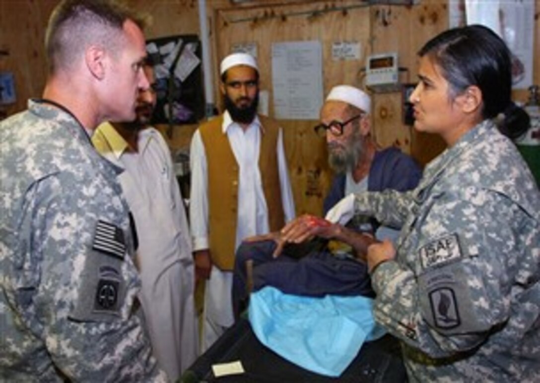 U.S. Army Maj. Saira Saini, a plastic surgeon, and Maj. Lee J. Trombetta,a  general surgeon, both with the 555th Forward Surgical Team, consult with each other Oct. 8, 2007, regarding a snake bite.  