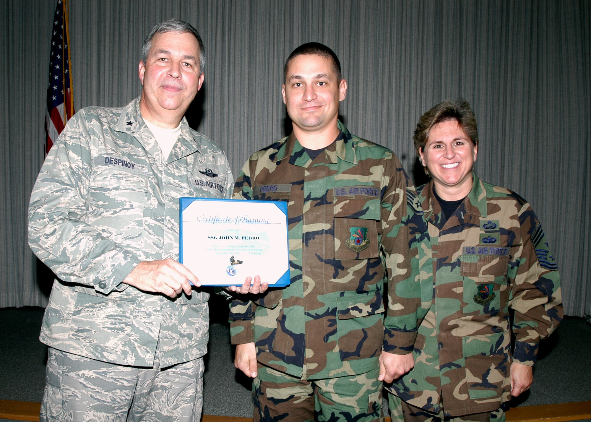 GRISSOM AIR RESERVE BASE, Ind., -- Staff Sgt. John Pedro, hydraulics specialist for the 434th Air Maintenance Squadron receives a certificate-of-training for completing the Non-Commissioned Officer Leadership Development Course. There were a total of 15 graduates on Nov. 2. Presenting the certificate are Brig. Gen. Dean Despinoy, 434th Air Refueling Wing commander (left), and Chief Master Sergeant Peri Rogowski. (U.S. Air Force photo/Senior Airman Carl Berry)