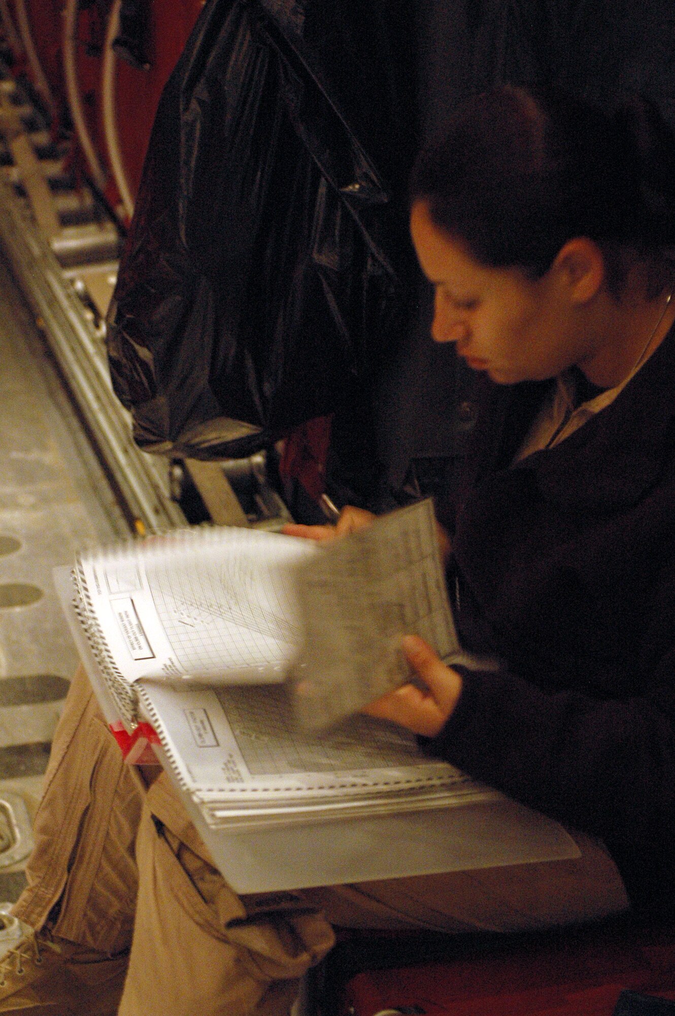 SOUTHWEST ASIA - Staff Sgt. Amanda Murdock, 40th Expeditionary Airlift Squadron flight engineer, documents a C-130's aircraft forms during a brief refueling stop. The aircraft crew also landed to load 300,000 leaflets to dropped over an area of Afghanistan. (U.S. Air Force photo/Staff Sgt. Jason Barebo)