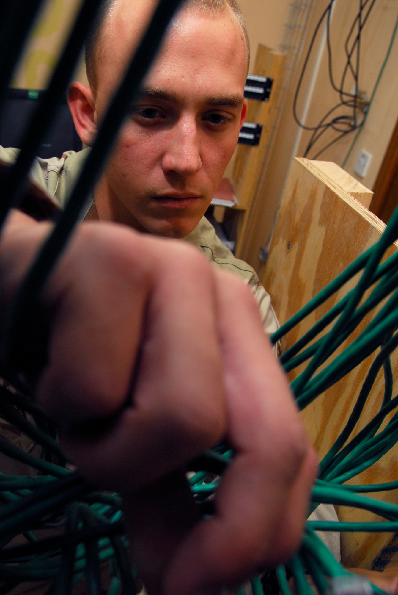 BALAD AIR BASE, Iraq -- Senior Airman Jonathan Zielinski, 332nd Expeditionary Mission Support Group Detachment 1 Mayor Cell automations technician, connects patches to a  panel. The patch panel is the hub that connects users to the network. Airman Zielinski is deployed from Buckley Air Force Base, Colo. (U.S. Air Force photo/Staff Sgt. Joshua Garcia)

