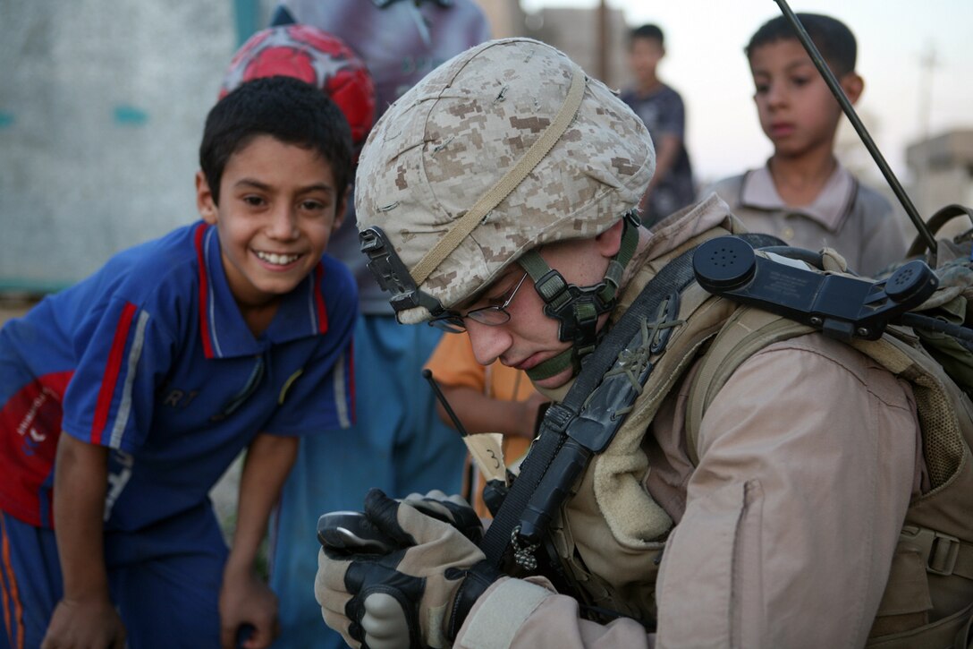 Cpl. Jordan M. Moehnle, 21, of Los Angeles, takes time out of leading his squad in a patrol through Fallujah's Nazaal district to spend some time interacting with local children. Moehnle, who is on his second tour in Iraq, said the changes he has witnessed since he was last here in 2006 have been dramatic. "The city was like the Wild West, we'd put our heads and and drive down (the middle of Fallujah) and hope not to get shot," he said. "Since we've been here (this year), we can stop and shoot the breeze."