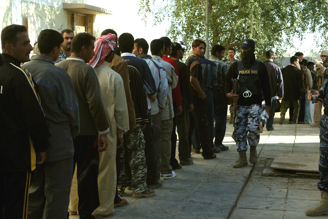 AL QA?IM, Iraq? Potential recruits line up outside the Ubaydi police station during a recruiting drive conducted by the district Police Transition Team and Task Force 3rd Battalion, 2nd Marine Regiment, Regimental Combat Team 2. In addition to providing security for the event, the elements of the recruiting team conducted a thorough screening of each applicant who included literacy testing, medical evaluations, administrative processing, security questionnaires and a physical fitness test.