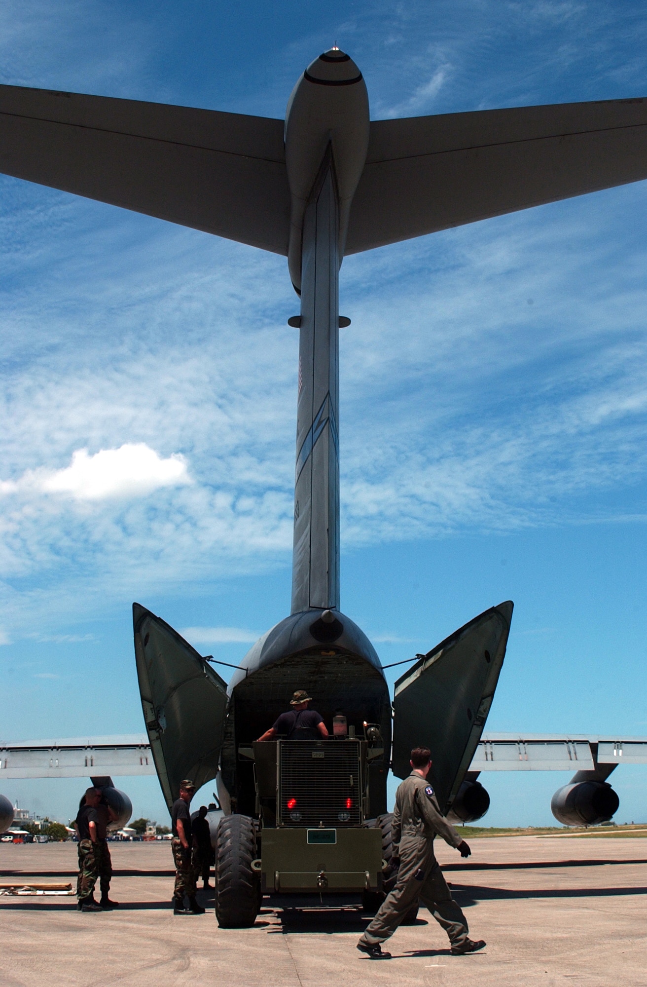 PORT-AU-PRINCE, Haiti -- Under a Caribbean sky, 84th Aerial Port Squadron Airmen worked with a C-141 Starlifter crew to load and unload cargo while supporting Operation Secure Tomorrow in 2004.  