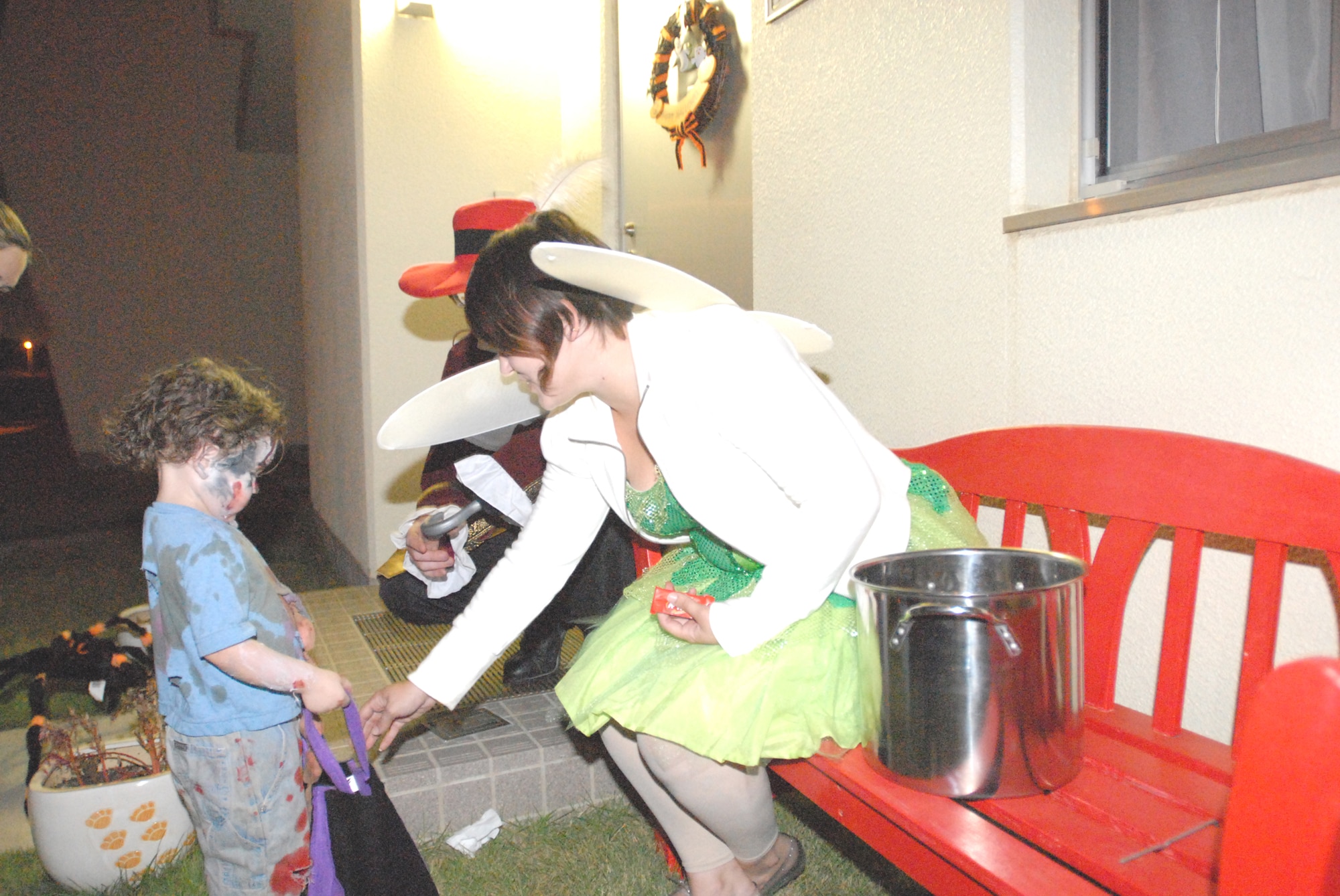 Stephanie Rickert, Marine Air Control Group 18, passes out candy to a child Halloween night. (U.S. Air Force photo/Airman 1st Class Kasey Zickmund)
