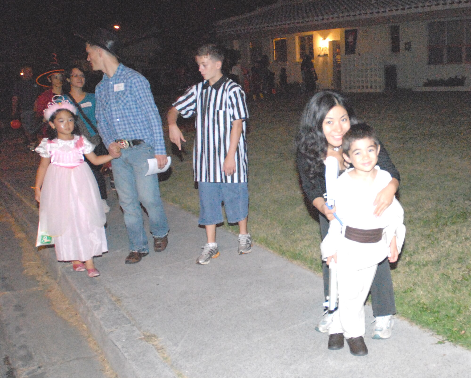 Kaori Shimabukuro and her son Kai (right) enjoy trick or treating in Kadena’s housing areas with others from the community Halloween night. (U.S. Air Force photo/Airman 1st Class Kasey Zickmund)