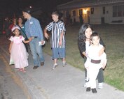 Kaori Shimabukuro and her son Kai (right) enjoy trick or treating in Kadena’s housing areas with others from the community Halloween night. (U.S. Air Force photo/Airman 1st Class Kasey Zickmund)