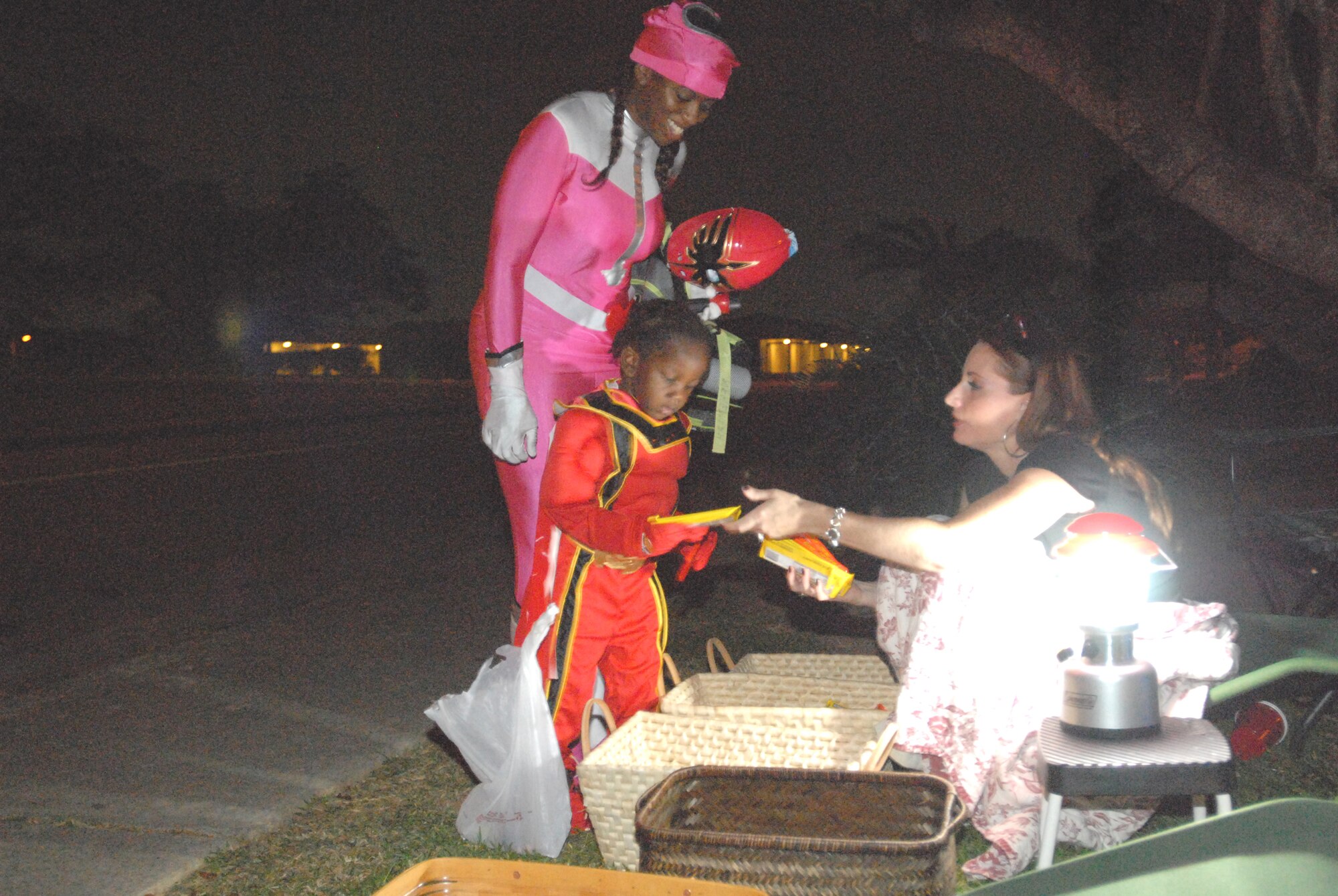 Molly Donovan, wife of Lt. Col. Paul Donovan, 353rd Operations Support Squadron, gives candy to Nehemiah and his mom, Staff Sgt. Keneisha Fuller, 18th Medical Operations Squadron, Oct. 31, 2007. (U.S. Air Force photo/Airman 1st Class Kasey Zickmund)