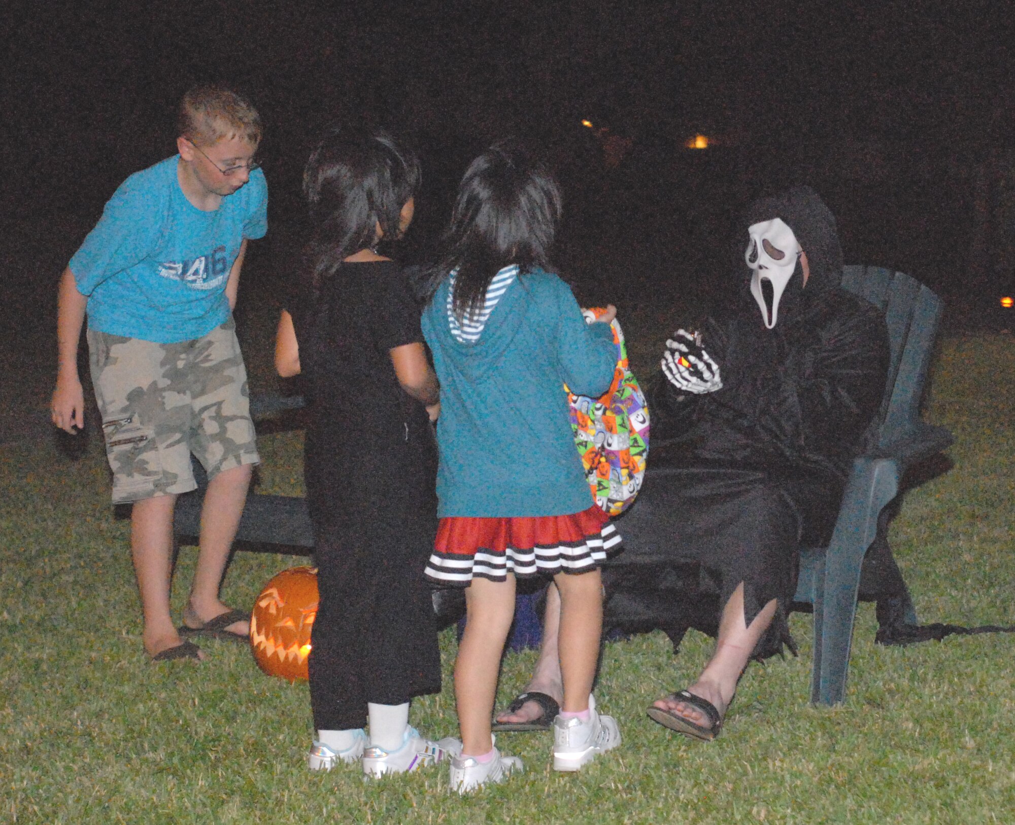 Lt. Col. Edward O’Neill, 1-1 Air Defense Artillery Battalion, gives out candy to two local girls on Halloween night. (U.S. Air Force photo/Airman 1st Class Kasey Zickmund)