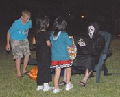 Lt. Col. Edward O’Neill, 1-1 Air Defense Artillery Battalion, gives out candy to two local girls on Halloween night. (U.S. Air Force photo/Airman 1st Class Kasey Zickmund)