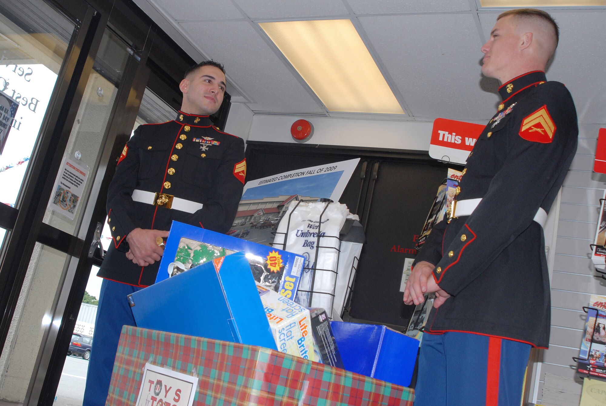 Cpl. Cody Bryant and Cpl. Kyle Cox man the front door of the Base Exchange at Kadena Air Force Base during the Toys for Tots drive. The annual drive collects toys for needy children all over the world. (U.S. Air Force photo/Airman 1st Class Ryan Ivacic)