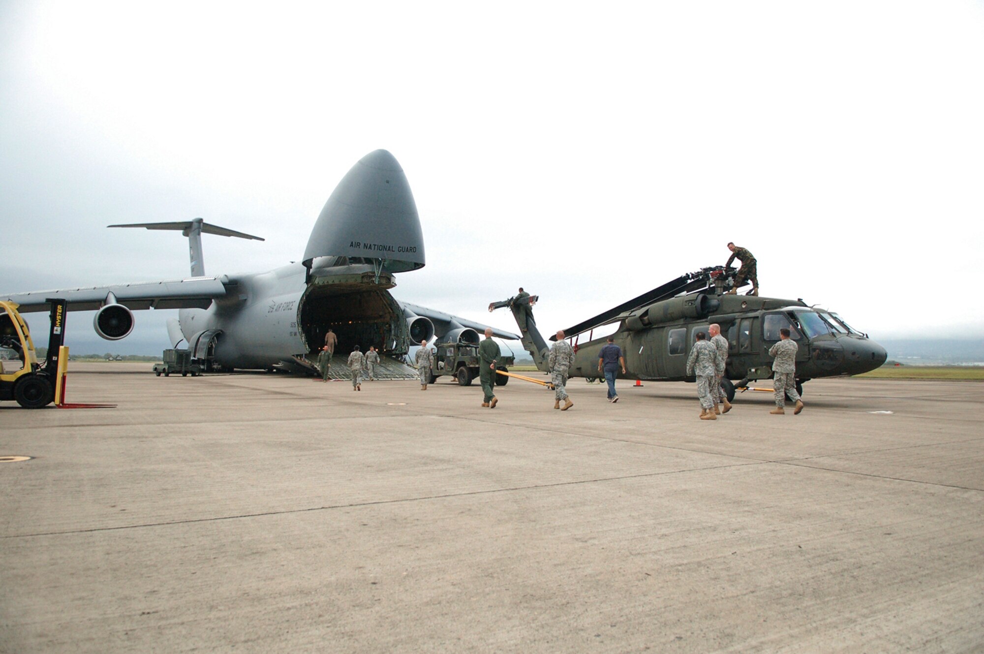 Soldiers and Airmen from Joint Task Force-Bravo here position a UH-60 Black Hawk helicopter for loading onto a C-5 Galaxy from the New York Air National Guard.  A team of 19 Airmen and Soldiers and two helicopters from Joint Task Force-Bravo departed here Nov. 5 heading for the Dominican Republic to assist with recovery efforts in the wake of Tropical Storm Noel. (U.S. Air Force photo/Staff Sgt. Austin M. May) 