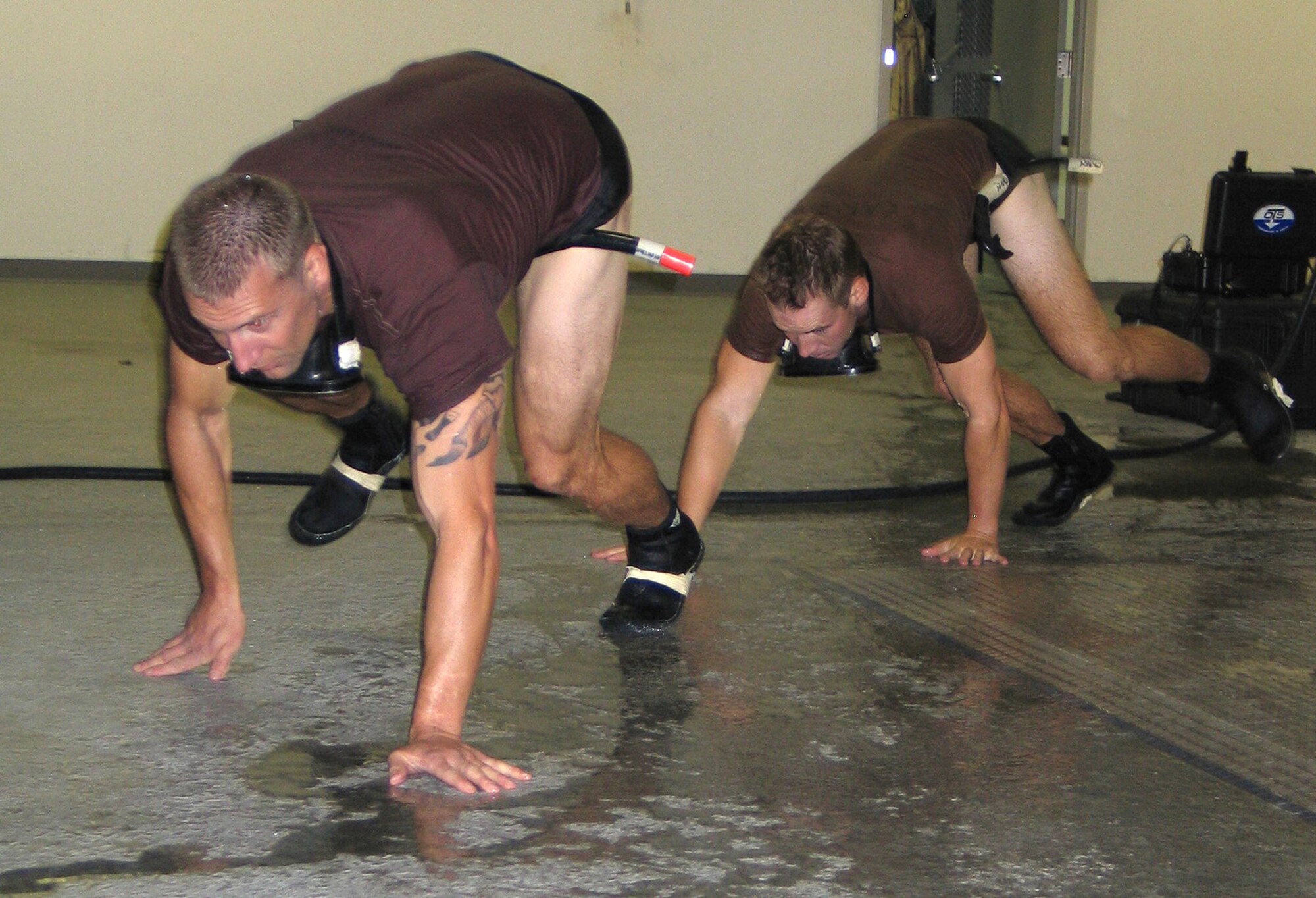 Lt. Cody Atchinson (front), and Navy Ensign Brian Carey bear-crawl around the pool at Fairchild Air Force Base, Wash., Oct. 24 during the water confidence portion of the combat rescue officer selection program. During water confidence as in other evaluation segments as well, CRO candidates test and train their teamwork, endurance and leadership skills. (U.S. Air Force photo/Staff Sgt. Connie L. Bias) 

