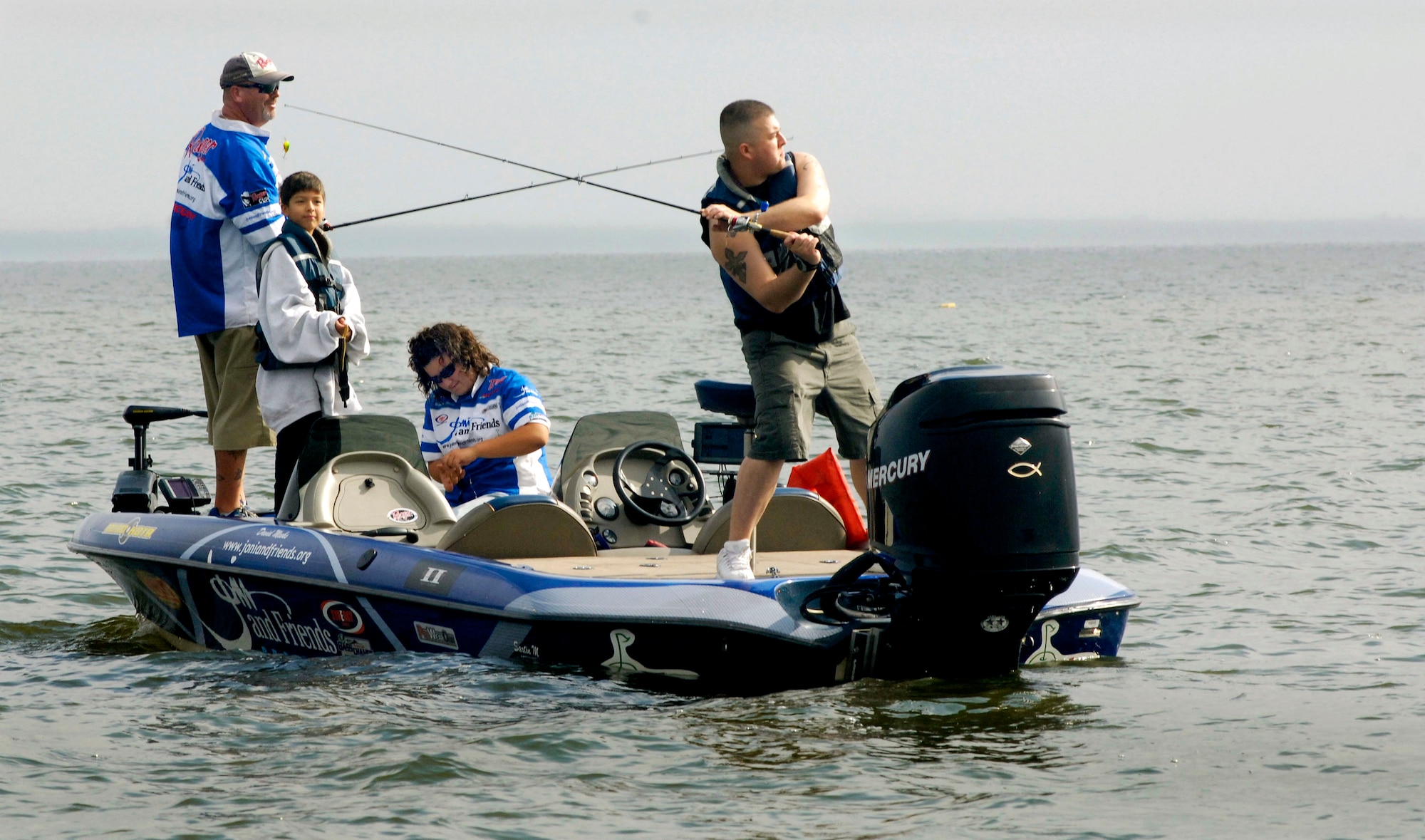 Army Sgt. Joseph Reyes, right, casts from the back of a bass boat Nov. 3, at Choke Canyon Reservoir, Texas, during the fourth annual Fishing For Freedom event held by the Quality Bass Club of San Antonio. (U.S. Air Force photo/Michael Tolzmann)