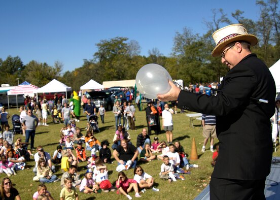 SCOTT AIR FORCE BASE, Ill. -- Mark “Marvin the Magician” Poole performs a balloon trick during a magic show during the Fall Popcorn Festival held at Scott Lake. The Popcorn festival featured free food, hayrides, games, bouncy castles, pumpkin decorating, face painting, pie bake-off and much more for families of Joint Total Force Scott. (U.S. Air Force photo by Marv Lynchard)