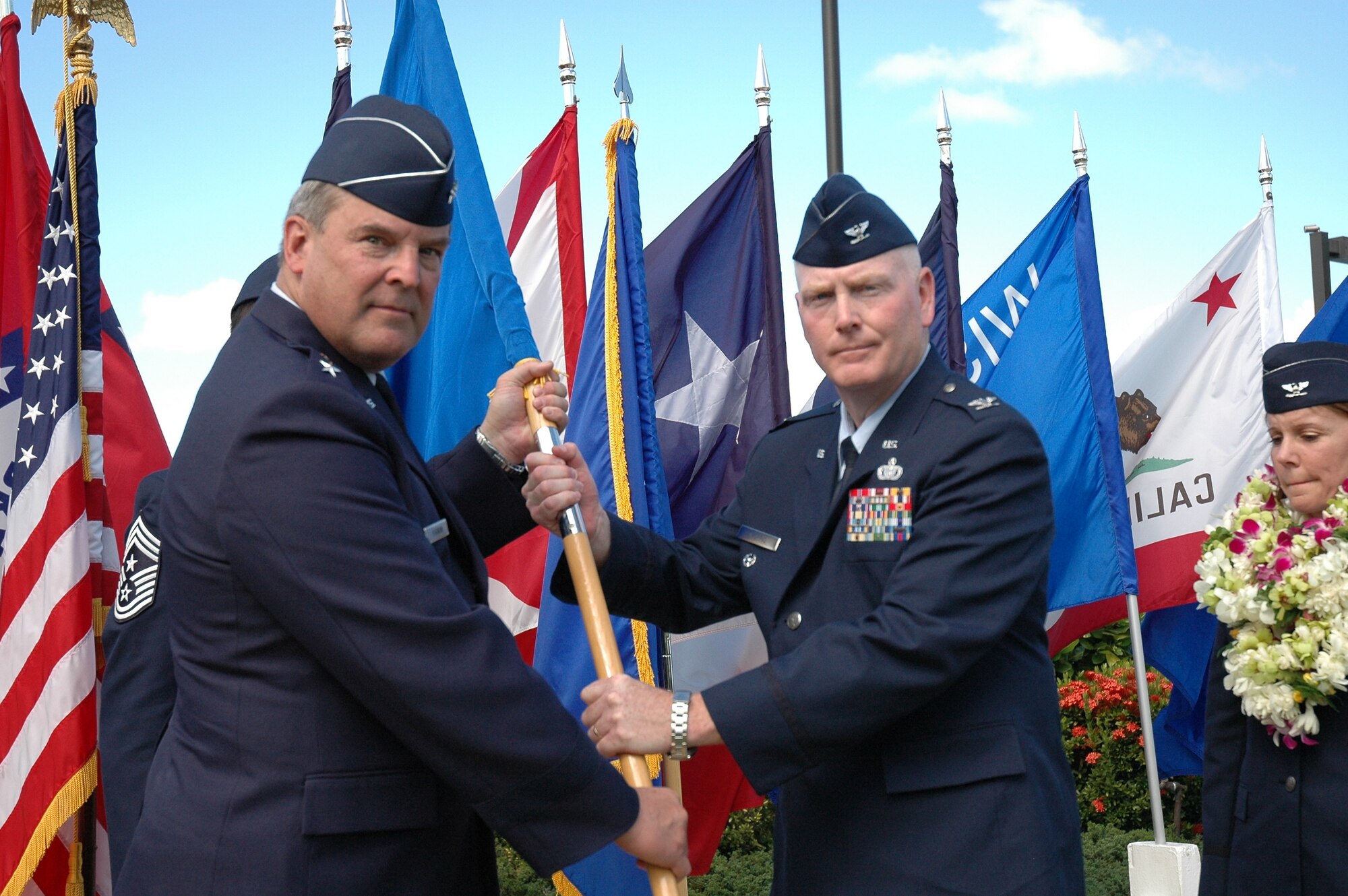 Maj. Gen. Robert Duignan, 4th Air Force commander at March Air Reserve Base, passes the command flag to Col. John Morris, commander 624th Regional Support Group, during a change of command ceremony Oct. 14. Out-going commander, Col. Pamela Milligan (right) watches.  (U.S. Air Force photo by SSgt Jennie Chamberlin)