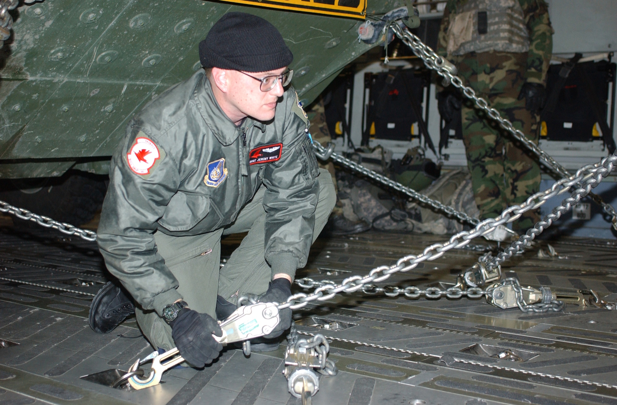 ELMENDORF AIR FORCE BASE, Alaska-- Air Force Staff Sgt. Jeremy White, a loadmaster with the 517th Airlift Squadron and an Orlando, Fla., native, secures a Stryker in a C-17 aircraft during a deployment readiness exercise with Soldiers from 1st Battalion, 24th Infantry Regiment, 1st Stryker Brigade Combat Team, 25th Infantry Division, at Eielson Air Force Base Oct. 30. (U.S. Army photo by Spc. Vincent Fusco) (Released)