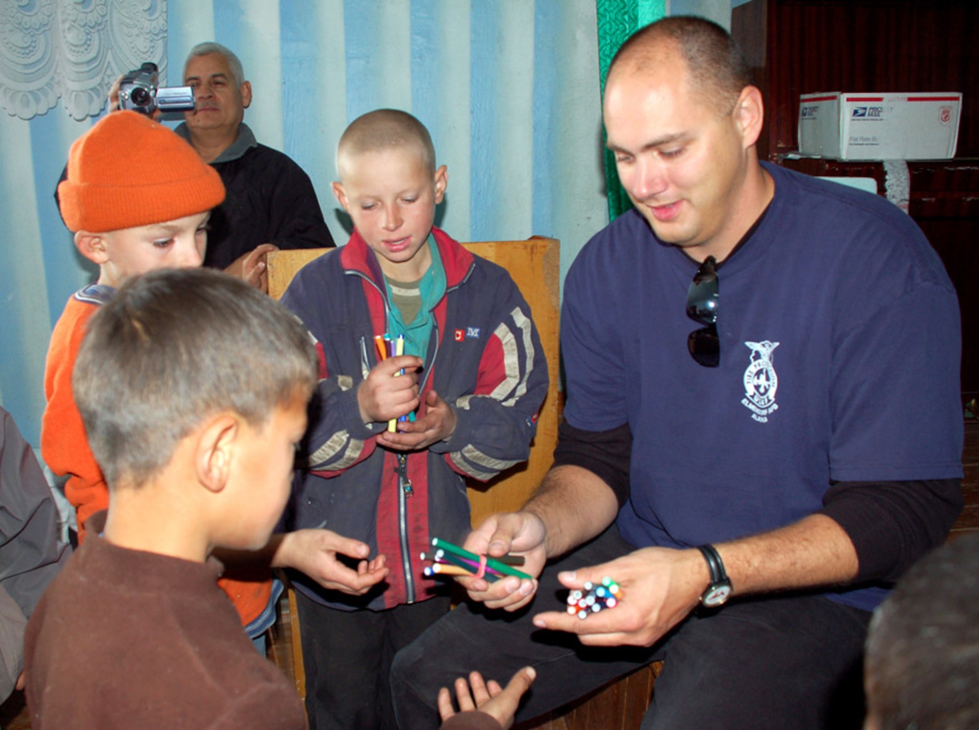Master Sgt. Joseph Debets, 376th Expeditionary Civil Engineer Squadron, passes out colored markers to children at the Tok Mok II Orphanage, near Manas Air Base, Kyrgyzstan, Oct. 29. (U.S. Air Force photo/Senior Master Sgt. Stefan Alford)