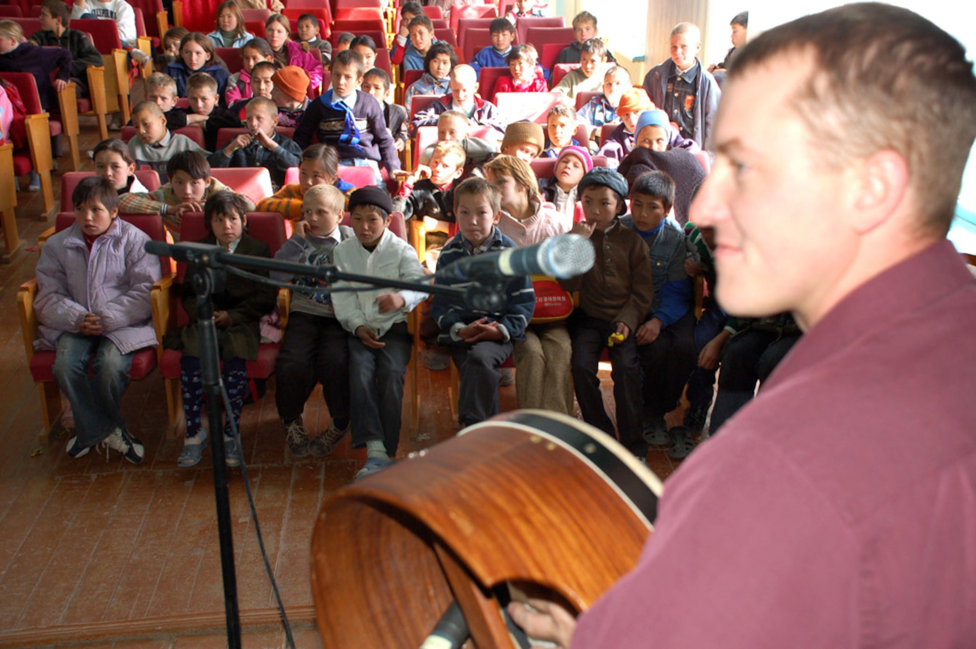 Airman 1st Class Brandon Richard, U.S. Central Air Forces Band, the Desert Ramblers, plays a song to the children at the Tok Mok II Orphanage near Manas Air Base, Kyrgyzstan, Oct. 29. (U.S. Air Force photo/Senior Master Sgt. Stefan Alford)