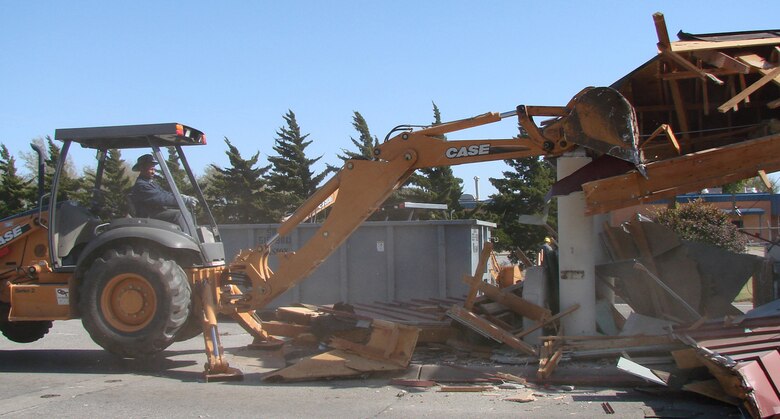 Construction worker Jeff Farmer with One Way Construction from Oklahoma City, operates a loader/backhoe to demolish the old Hairston Gate guard facility Nov. 3. This completes the transition to the new Master Sgt. James A. Hairston gate that was officially opened Sept. 21. (U.S. Air Force photo by Tech. Sgt. Mary Davis)