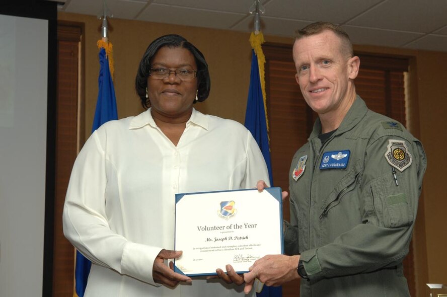 Mr. Joseph Patrick's wife accepts his award from Col. Kent Laughbaum, 355th Fighter Wing commander. (Courtesy photo)