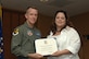 Ms. Daneen Rivera accepts his award from Col. Kent Laughbaum, 355th Fighter Wing commander. (Courtesy photo)