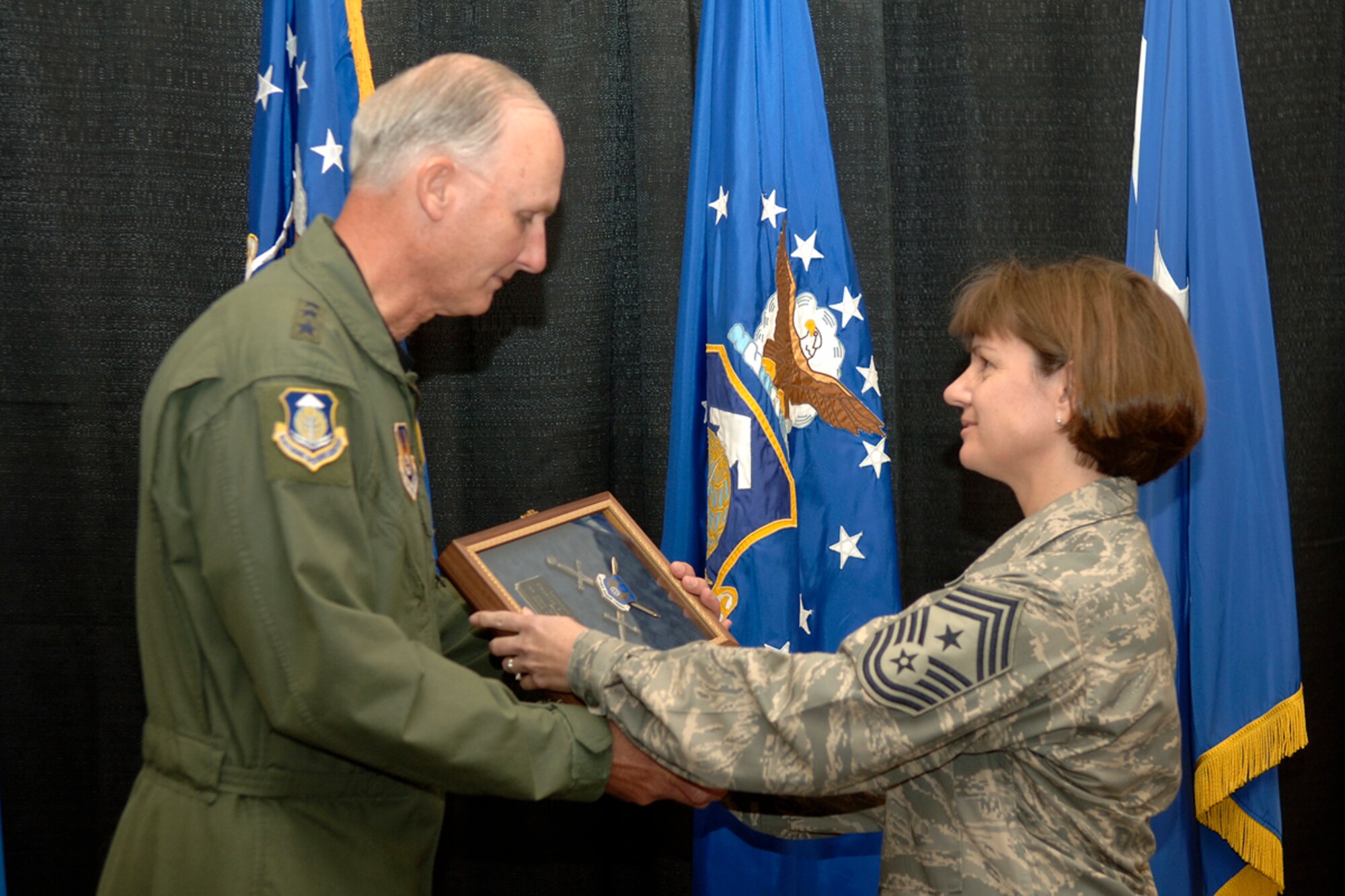 HANSCOM AFB, Mass. -- Chief Master Sgt. Lisa Sirois, Electronic Systems Center and 66th Air Base Wing command chief, presents ESC Commander Lt. Gen. Chuck Johnson with an invitation to be inducted into Order of the Sword during an enlisted call at the Hanscom Conference Center Nov. 1. ESC’s noncommissioned officers surprised the general with the Order of the Sword invitation, the highest honor and tribute NCOs can bestow. The actual induction ceremony will be held June 20, 2008, at Hanscom. The Order of the Sword, steeped in tradition dating back to the Middle Ages, honors General Johnson’s devotion to the enlisted corps.  (U.S. Air Force photo by Jan Abate) 