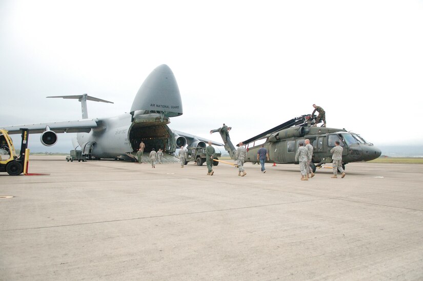 SOTO CANO AIR BASE, Honduras -- Soldiers and Airmen from Joint Task Force-Bravo here position a UH-60 Black Hawk helicopter for loading onto a C-5 Galaxy from the New York Air National Guard.  A team of 19 Airmen and Soldiers and two helicopters from Joint Task Force-Bravo departed here Nov. 5 heading for the Dominican Republic to assist with recovery efforts in the wake of Tropical Storm Noel. (U.S. Air Force photo/Staff Sgt. Austin M. May) 