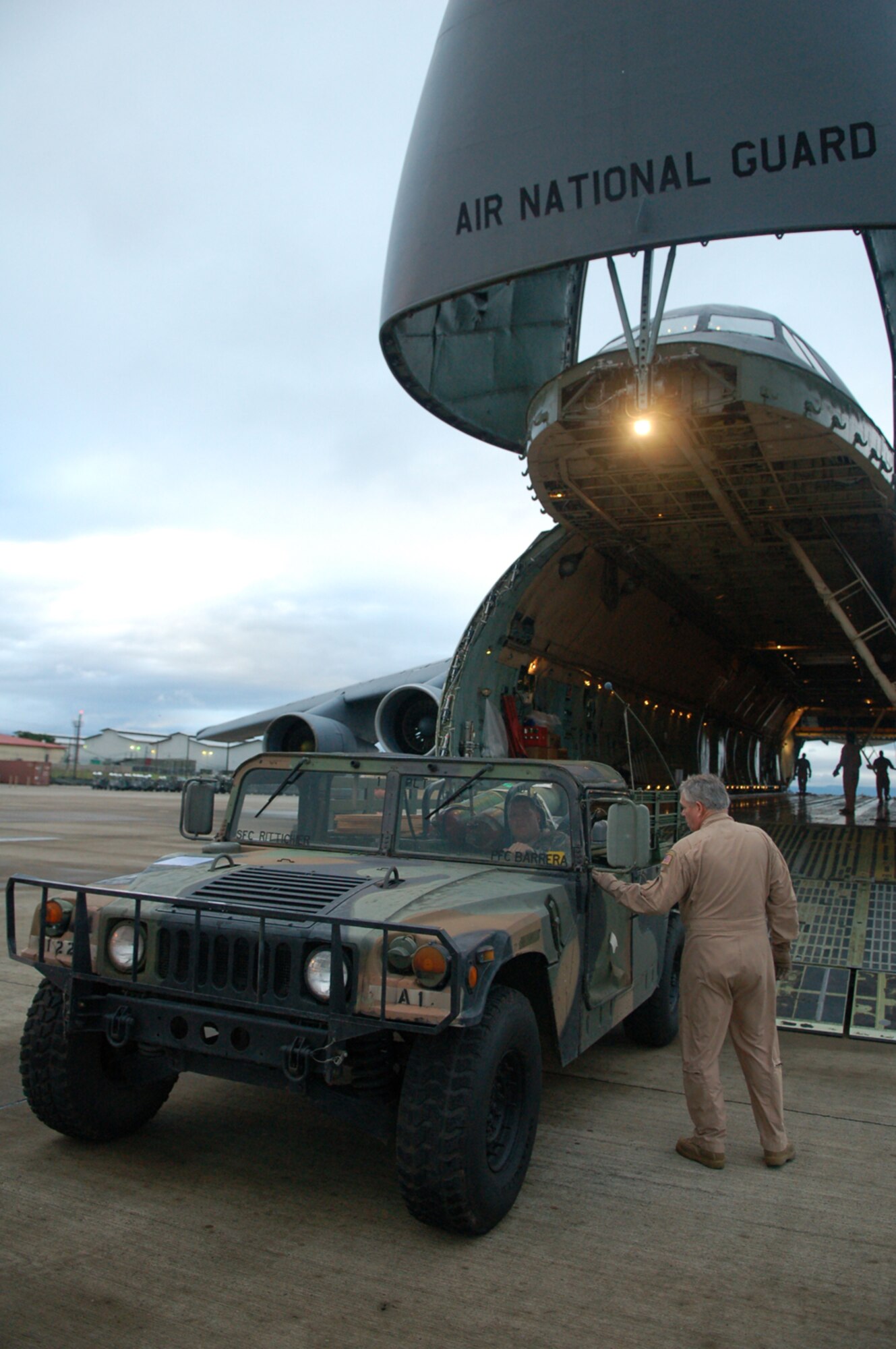 SOTO CANO AIR BASE, Honduras -- Master Sgt. Bob Mechan, a C-5 loadmaster with the New York Air National Guard, talks with Army Sgt. 1st Class Jason Rittichier, 1st Battalion, 228th Aviation Regiment, as he backs a humvee into the aircraft.  A team of 19 Airmen and Soldiers and two helicopters from Joint Task Force-Bravo departed here Nov. 5 heading for the Dominican Republic to assist with recovery efforts in the wake of Tropical Storm Noel. (U.S. Air Force photo/Staff Sgt. Austin M. May) 