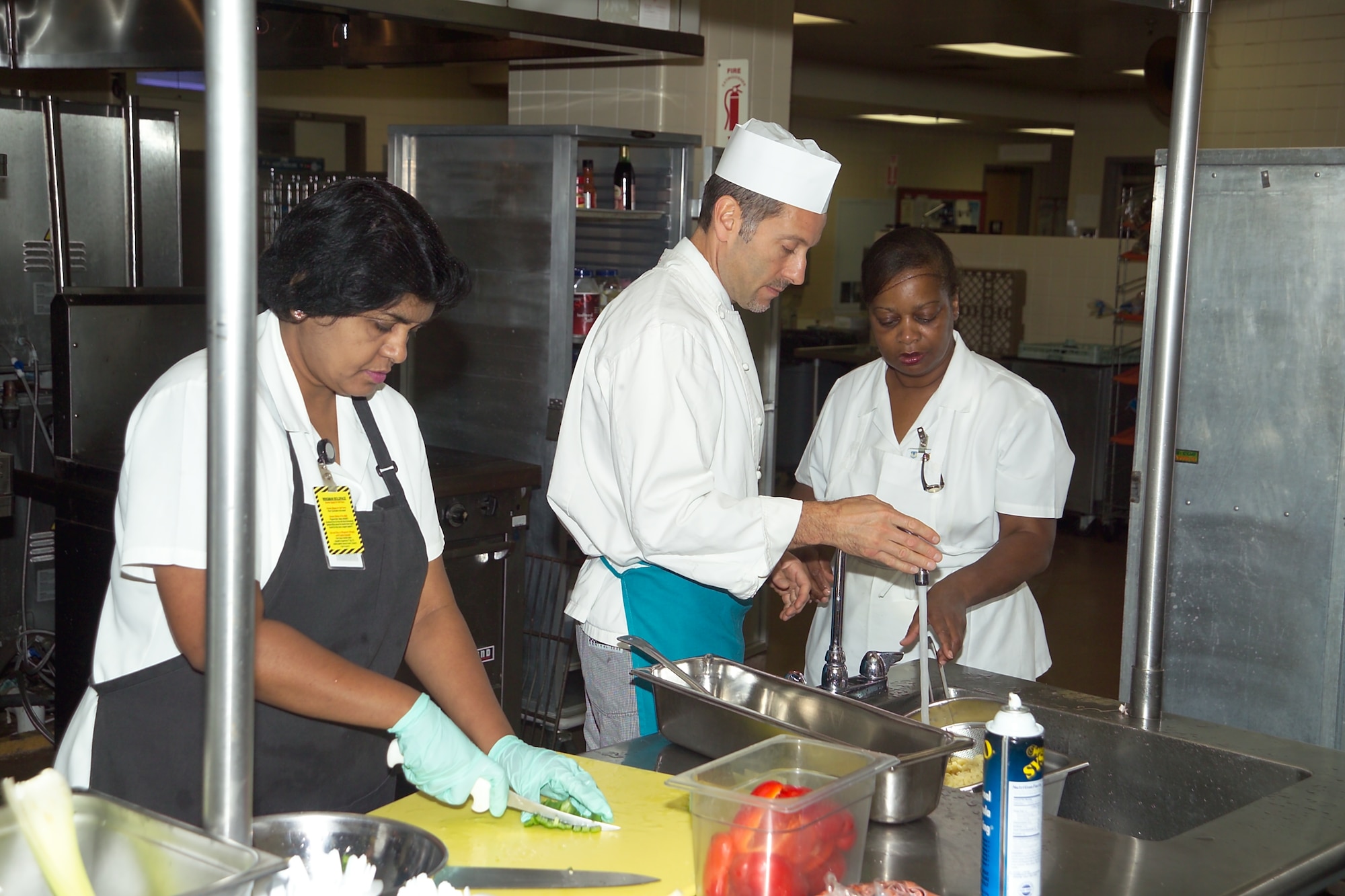 Askoa Munaweera, left, hones her knife skills while Chef Ken Arnone shows Deborah Smith how to shock pasta in an ice bath to prevent overcooking. The pasta and vegetables were used to create a flavorful, lower fat chili macaroni dish during the master chef’s class on healthy cooking techniques. Both women are with the nutritional medicine flight at the Wright-Patterson Medical Center. (Air Force photo by Mark Pugel)