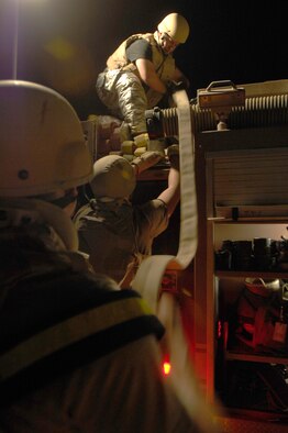 ALI AIR BASE, Iraq -- Technical Sgt. Steven Lawter pulls up a hose after putting out a simulated fire Nov. 1 during a major accident response exercise. This exercise is designed to test how Airmen will react and the response time of emergency teams to treat the victims and ultimately working together as a team. Sergeant Lawter is assigned to the 407th Expeditionary Civil Engineer Squadron and is deployed from Royal Air Force Mildenhall, England. (U.S. Air Force photo/Airman 1st Class Jonathan Snyder)