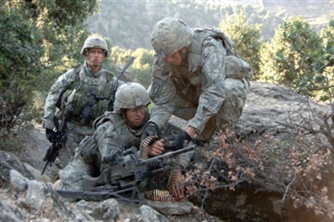 U.S. Army Sgt. 1st Class Matthew Kahler (left) supervises and provides security for Pfcs. Jonathan Ayers and Adam Hamby while they emplace an M240 machine gun as part of a fighting position in the mountains of Afghanistan's Kunar Province on Oct. 23, 2007.  The soldiers are all from 2nd Battalion, 503rd Parachute Infantry Regiment.  