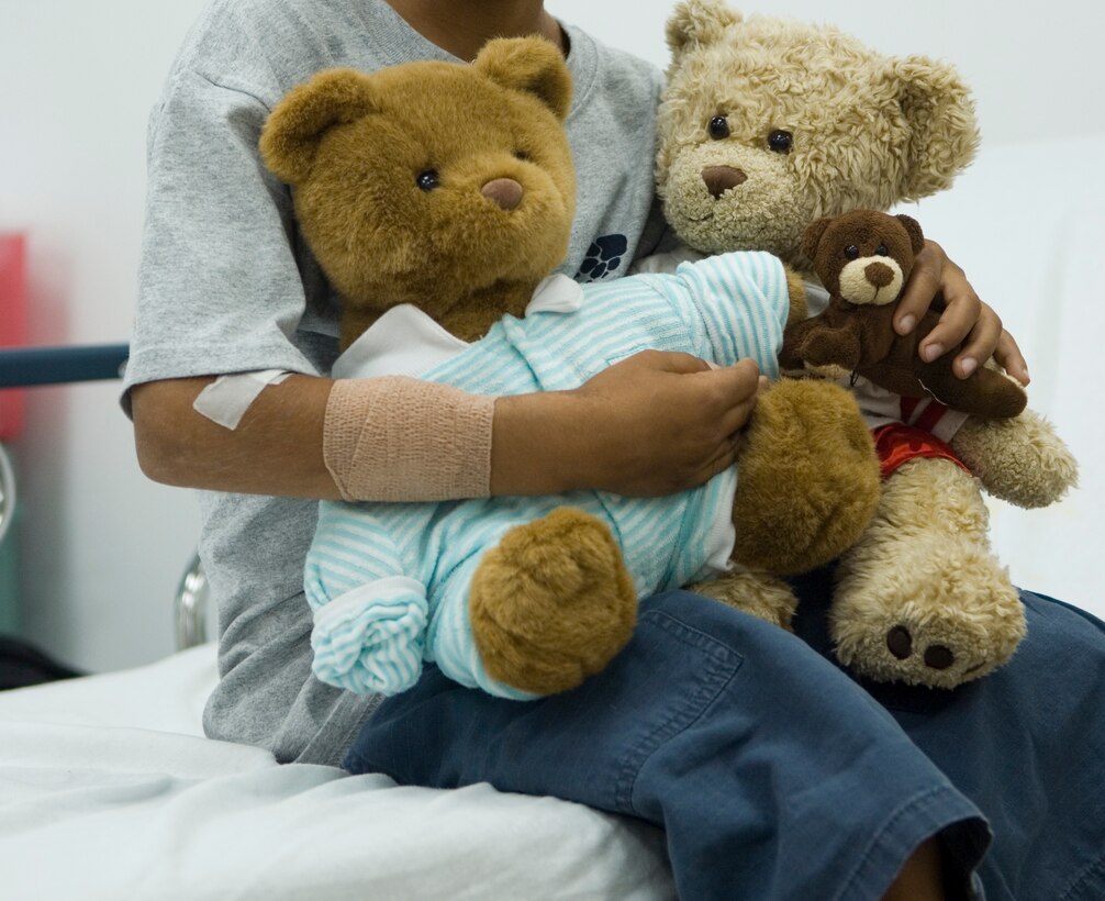 An Iraqi child embraces the bears given to him during his recovery at the Air Force Theater Hospital at Balad Air Base, Iraq. Master Sgt. Dave Dunn started "Project Poppa Bear" to help the children in the hospital. Sergeant Dunn is the 332nd Medical Group first sergeant.  (U.S. Air Force photo/Senior Airman Travis Edwards) 