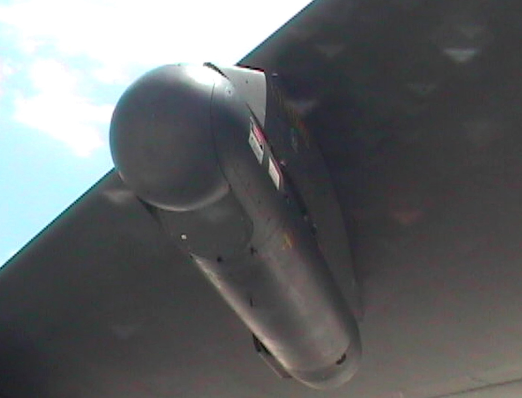 A LITENING pod sits under the wing of a B-52. The 49th Test and Evaluation Squadron's recent demonstration showed the B-52's LITENING pod's capability to capture digital imagery and upload it to communications networks. (U.S. Air Force photo)