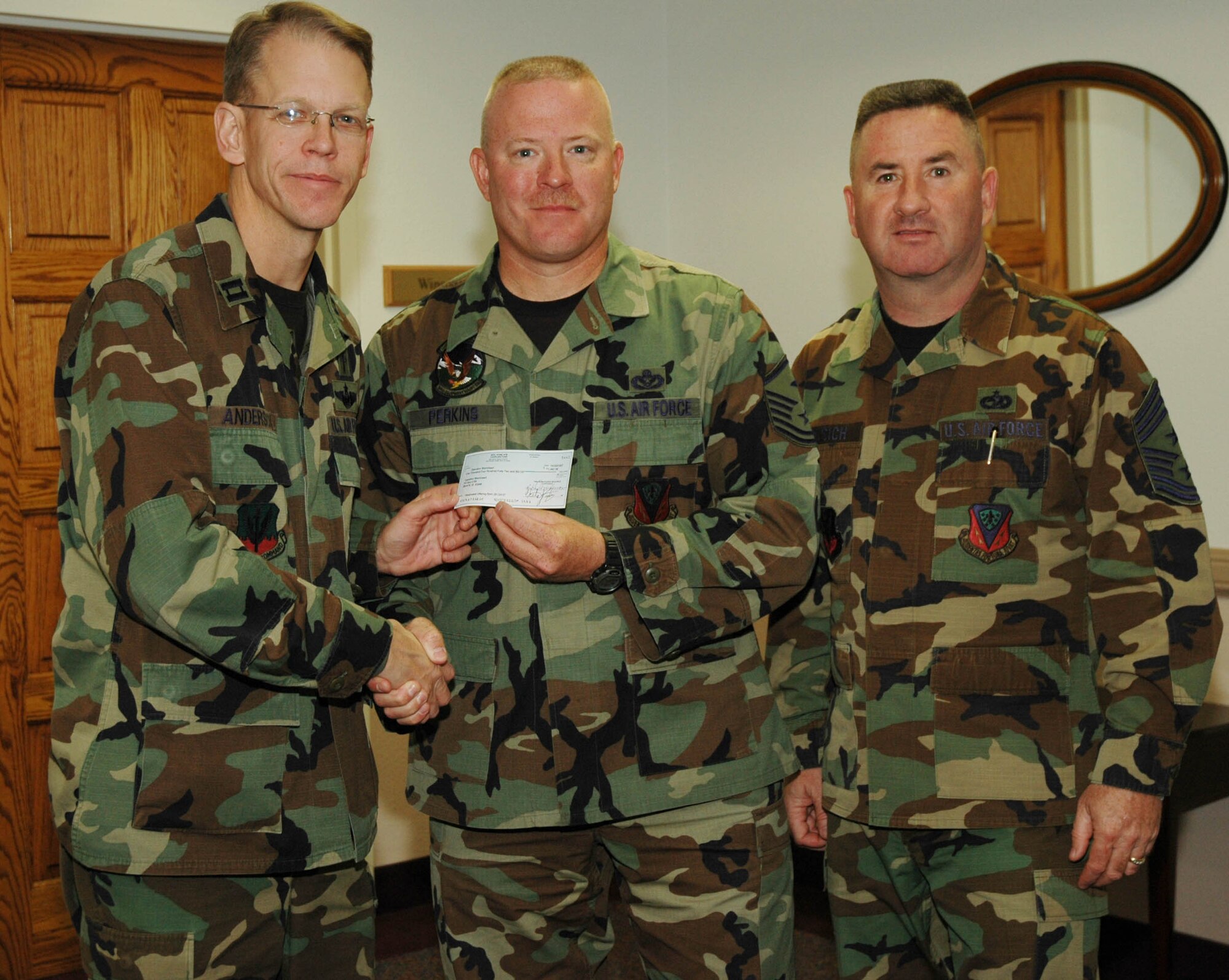 MOUNTAIN HOME AIR FORCE BASE, Idaho -- Chap. (Capt.) Richard Anderson, 366th Fighter Wing senior Protestant chaplain, donates a check for $1,442.99 to Master Sgt. Bruce Perkins, 366th Equipment Maintenance Squadron first sergeant, and Chief Master Sgt. Allen Niksich, 366th Fighter Wing Command Chief, for Operation Warmheart. The money was collected from offerings donated at the traditional and gospel Protestant services Oct. 28. Operation Warmheart is a non-profit organization designed to assist Airmen and their families during financially-strained times. The program is managed by the First Sergeants Council and supported by volunteers. For more information regarding volunteering or donating to Operation Warmheart, contact any squadron first sergeant. (U.S. Air Force photo/ Senior Airman Megan P. Lyon)
