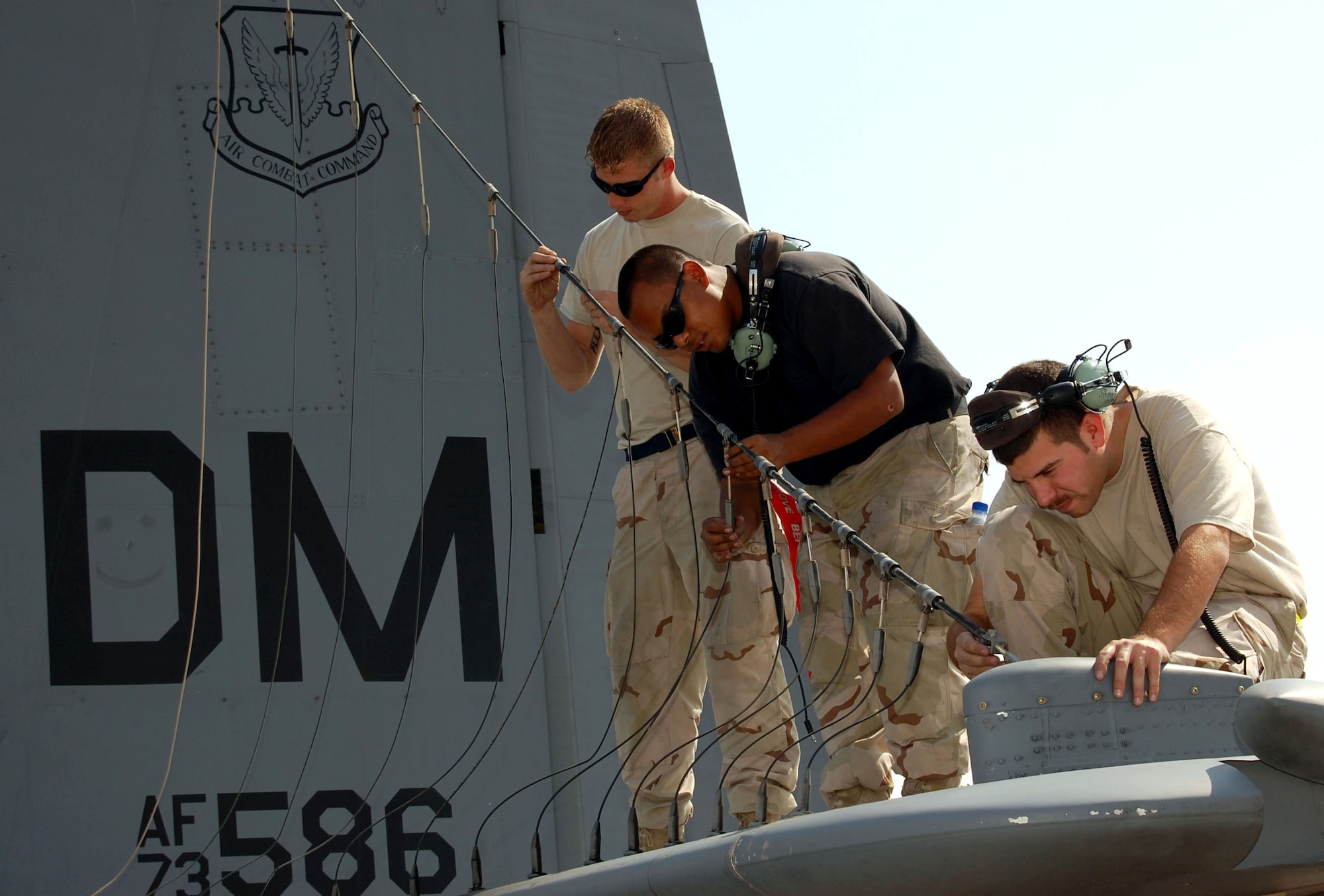 Airman 1st Class Paige Sager, (from left) Senior Airman David Garcia and Tech. Sgt. James Vehlies examine element connectors on a high-power antenna Oct. 30 in Southwest Asia.  The Airmen perform flightline maintenance on EC-130 Compass Call aircraft from the 43rd Expeditionary Electronic Combat Squadron.  Airmen Sager and Garcia are crew chiefs, and Sergeant Vehlies is an electro-environmental systems craftsman. (U.S. Air Force photo/Staff Sgt. Phillip Butterfield)