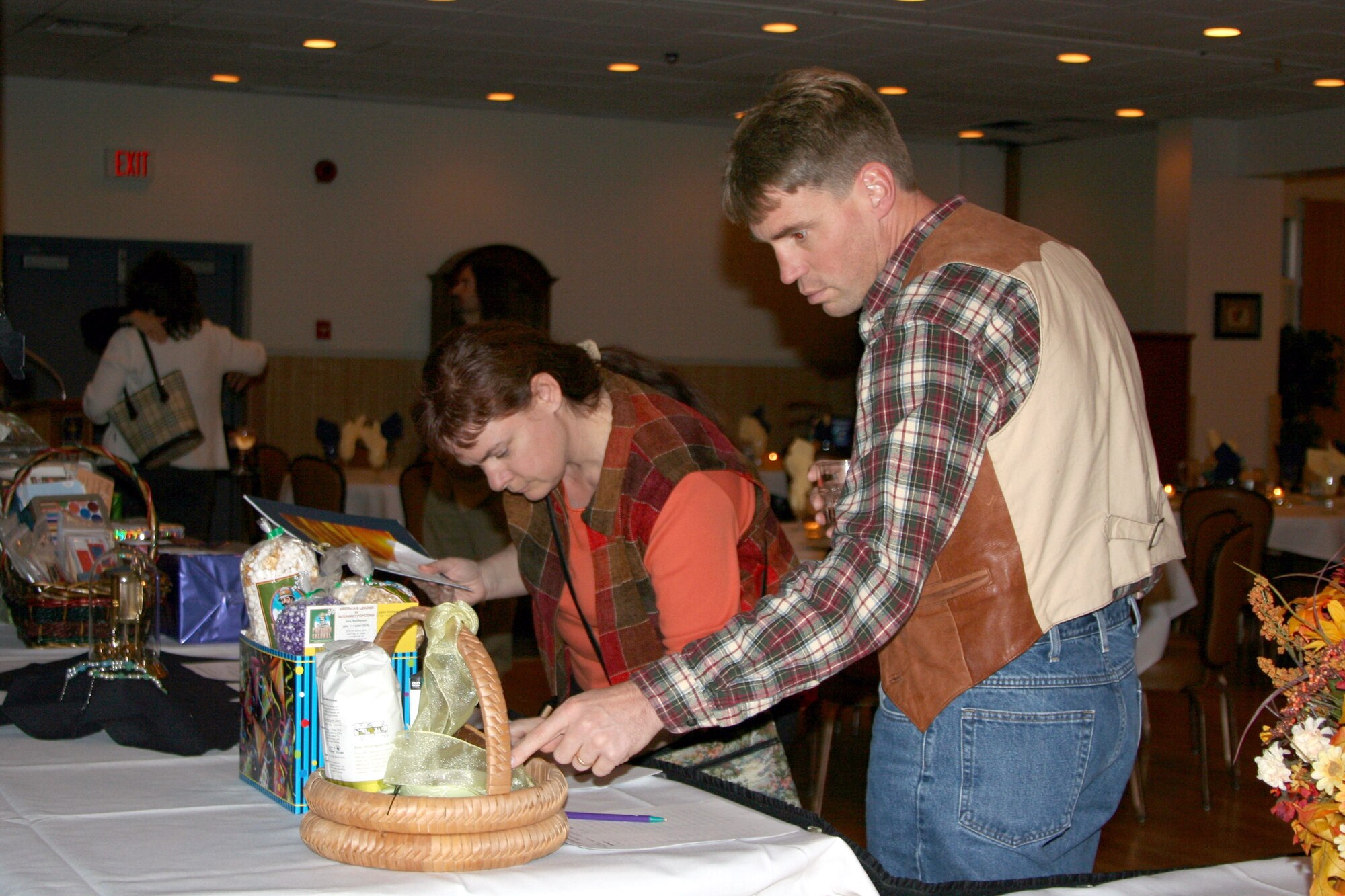 Lt. Col. Karyn Wright, 341st Mission Support Squadron, and Maj. Art Wickberg, 341st Missile Maintenance Squadron, check out the silent auction items at the 19th Annual Mercantile Auction Nov. 3 at the Grizzly Bend Club. The auction is a yearly event hosted by the Malmstrom Spouses' Club and proceeds benefit scholarships and local charities. (U.S. Air Force photo/Senior Airman Eydie Sakura)
