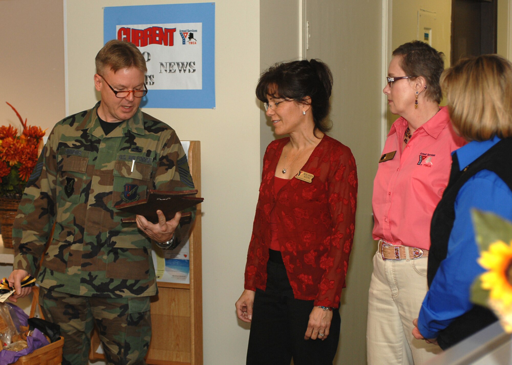 ELMENDORF AIR FORCE BASE, Alaska -- Senior Master Sgt. Vinson Simmons, 11th Air Force first sergeant, reads the plaque presented to the the Armed Services YMCA staff members Oct. 30 at the Kashim Club. The Elmendorf First Sergeant's Group honored the ASYMCA staff for their contributions to the base. (U.S. Air Force Photo by Airman 1st Class Laura Turner)