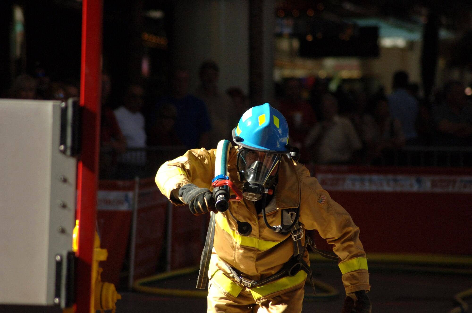 Air Force Academy firefighter Pat Kraft hauls a firehose over his shoulder to cross the 75 feet between him and where he needs to use the firehose to hit a volleyball-sized target during the World Firefighter Combat Challenge XVI in Las Vegas. The hose drag is the fourth of five events, which also include hauling a 42-pound firehose up five flights of stairs, using upper body strength to lift another 42-pound firehose up five stories via a rope, pounding a 160-pound sled weight five feet then running a 100-foot course, and finally dragging a 175-pound dummy backwards 106 feet. Mr. Kraft and his Academy teammates finished the events Nov. 5 in under two minutes, each. (U.S. Air Force photo/John Van Winkle)