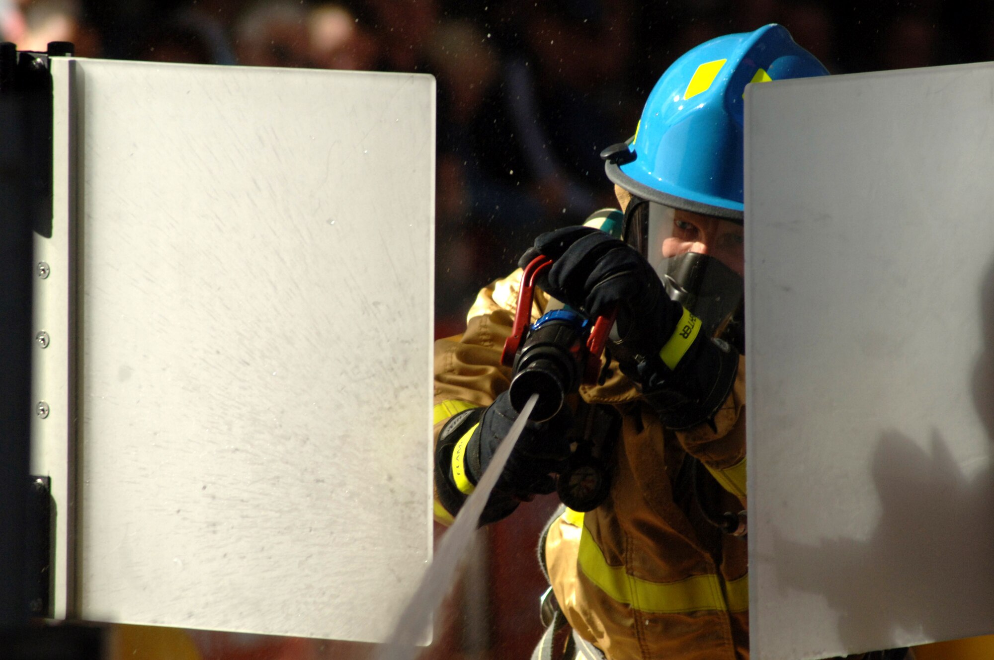 Air Force Academy firefighter Hans Barkley uses a firehose stream to hit a target just as he's through the target doors on a hydrant run event during the World Firefighter Combat Challenge XVI in Las Vegas. Every second counts in the timed events, which simulate the tasks a firefighter faces during a building fire. (U.S. Air Force photo/John Van Winkle)