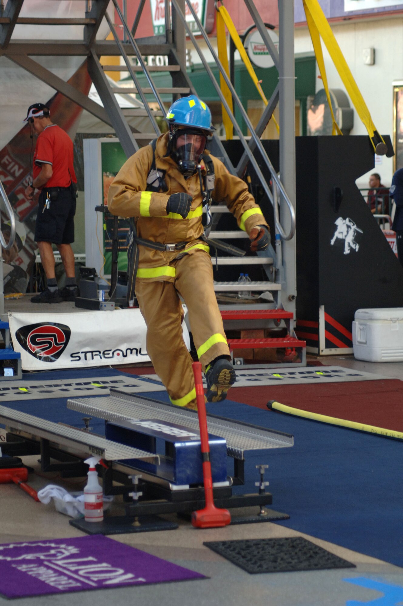 Air Force Academy firefighter Lance Gore hops to a Keiser sled to use a 9-pound mallet to drive a 160-pound steel beam a distance of five feet, thereby simulating the effort need to make a forced entry into a burning building. Mr. Gore and his Academy teammates are one of several military firefighter teams competing in the World Firefighter Combat Challenge XVI in Las Vegas. (U.S. Air Force photo/John Van Winkle)