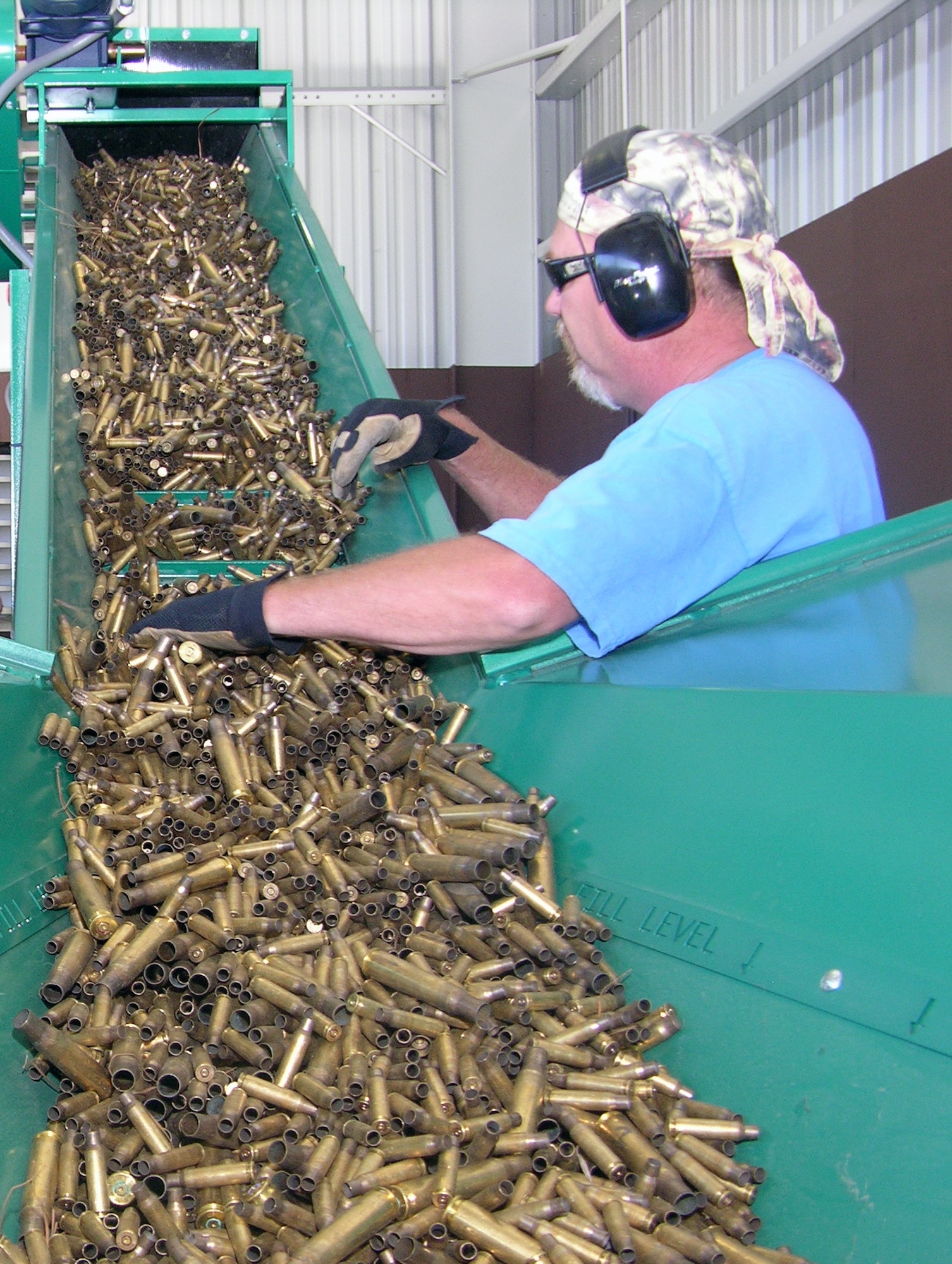 Tom Fujan runs expended small arms brass shells through Hurlburt Field's new ordnance deformer machine at the base recycling center Monday after a ribbon cutting ceremony. The machine is capable of processing up to 11,000 pounds of shells as large as .50 caliber in an hour. It renders them unusable and ready for sale. Annual income to the recycling center from the sale of this valuable commodity should increase by $70,000, providing additional funds for Hurlburt Field's quality of life programs. (U.S. Air Force photo by Jon Ortiz)
