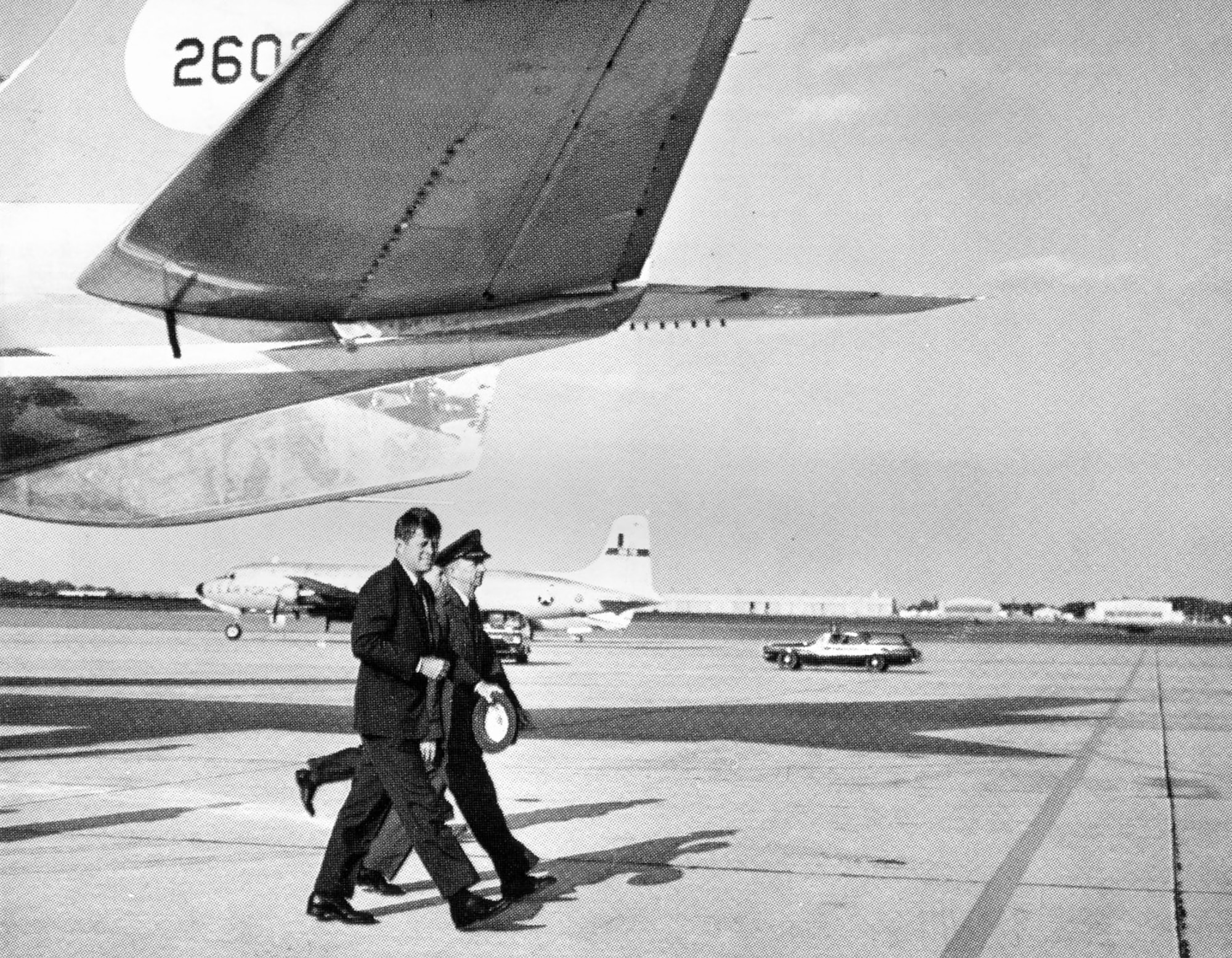 President John F. Kennedy walks with a base commander under the tail of Boeing VC-137C SAM 26000 (Air Force One). (U.S. Air Force photo)