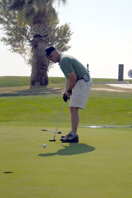 Marine Lt. Col. Thomas McCarthy, Marine Aircraft Group 46 Detachment Bravo commanding officer, makes a putt during the Toys for Tots kickoff golf tournament Oct. 26 at the Muroc Lake Golf Course here. (Photo by Senior Airman Julius Delos Reyes)