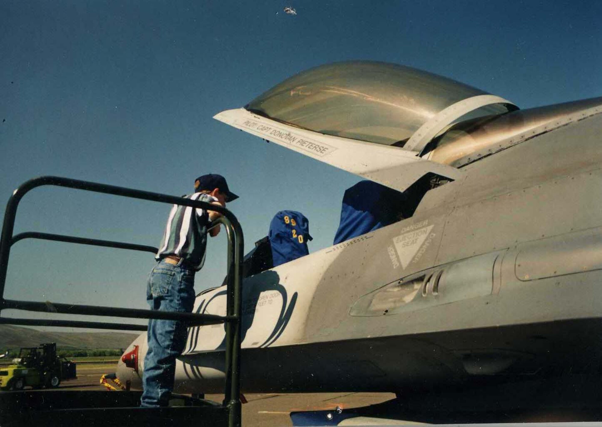 Senior Airman Jeremy Meyers seen here at 9 years old looking into an F-16 at an airshow.