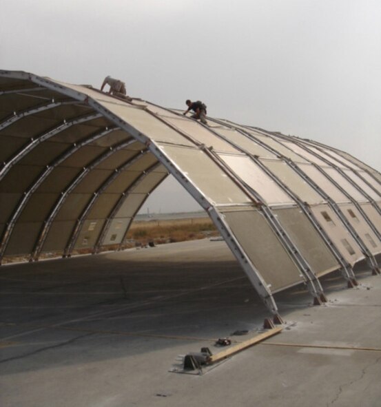 BAGRAM AIRFIELD, Afghanistan -- Deployed Airmen from the 49th Material Maintenance Group at Hollomon Air Force Base, N.M., put the finishing touches on one of the Air Force's largest ever deployable aircraft hangars here Nov. 1. The hangar is intended to simultaneously house up to three of the 455th Air Expedtionary Wing's combat search and rescue HH-60 Pave Hawk helicopters. The nine-person team erects and tears down similar structures throughout the U.S. Central Command Area of Responsibility. (Courtesy photo)                              
