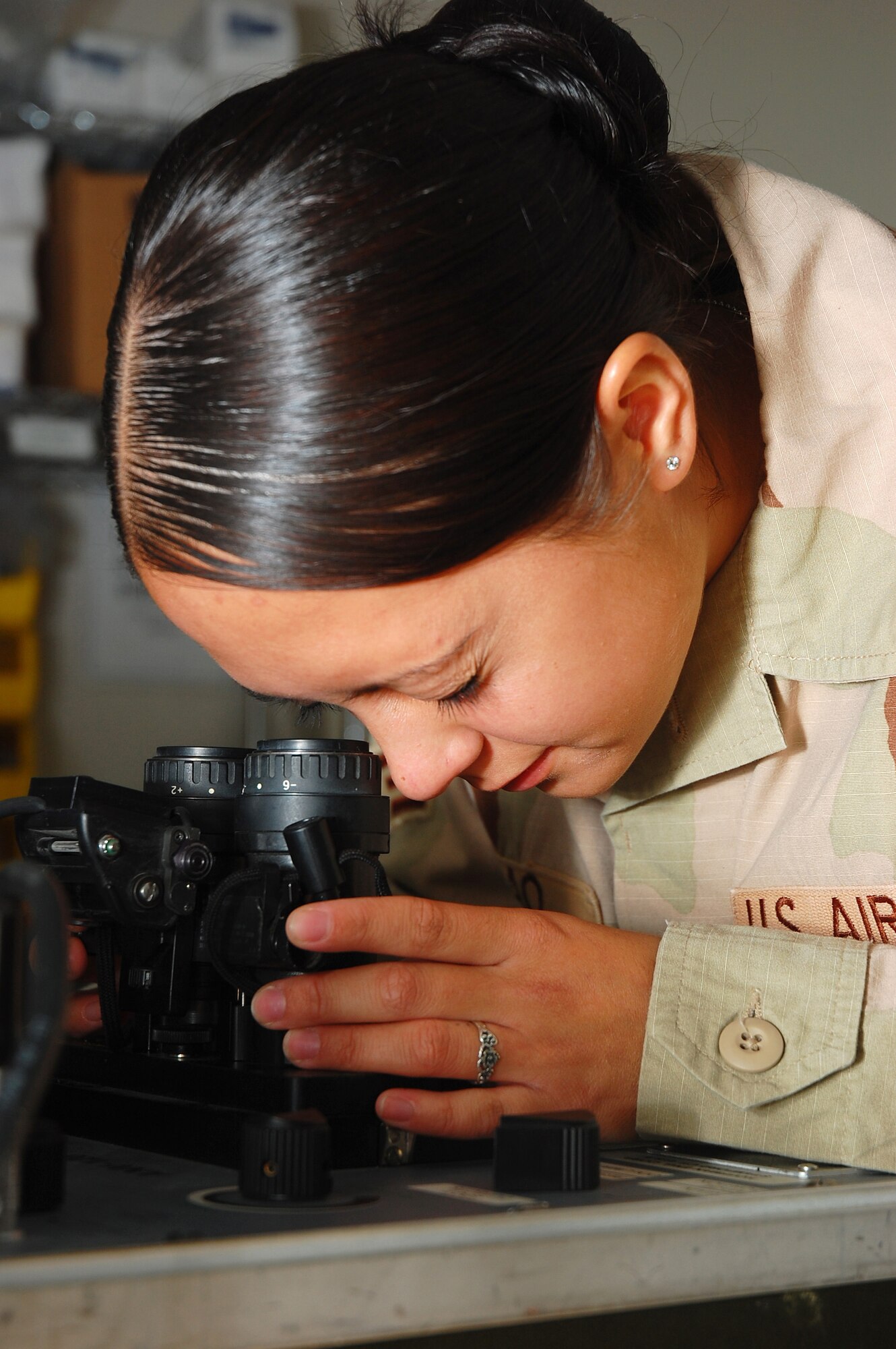 SOUTHWEST ASIA -- Senior Airman Christina Arao, 386th Expeditionary Operations Group aircrew life support technician, performs a periodic inspection of a set of night vision goggles Nov. 2 here.  Airman Arao is deployed from Pope AFB, N.C.  (U.S. Air Force photo by Staff Sgt. Tia Schroeder)