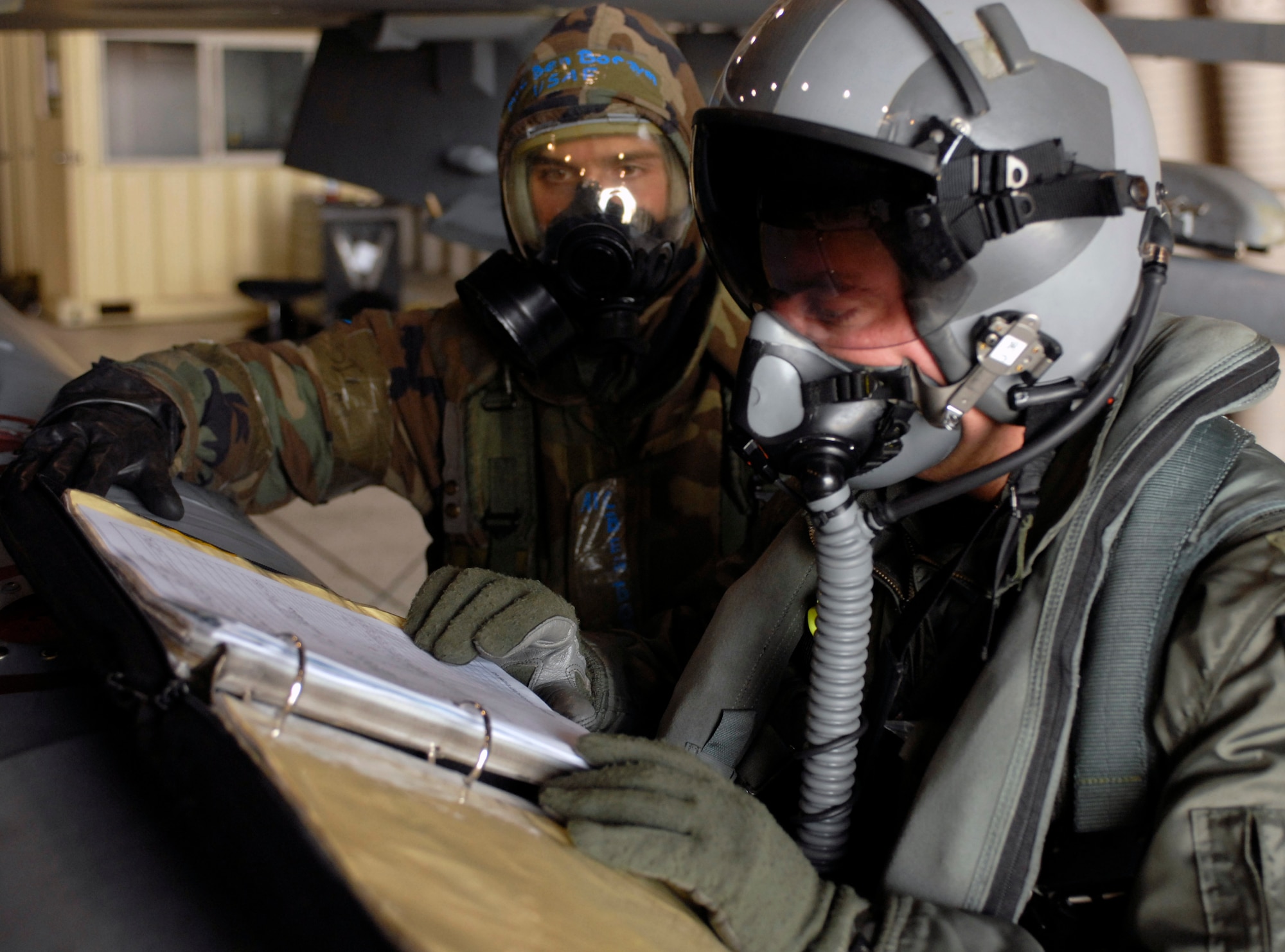 KUNSAN AIR BASE, South Korea -- Captain Darin Wetzler, a pilot with the 80th Fighter Squadron, and Airman 1st Class Ben Borzym, a crew chief with the 8th Aircraft Maintenance Squadron, review a checklist prior to take-off during the Peninsula Operational Readiness Exercise here Nov. 06.  The PENORE tests the wing's ability to train and work for a real world situation..  (U.S. Air Force photo/Senior Airman Steven R. Doty