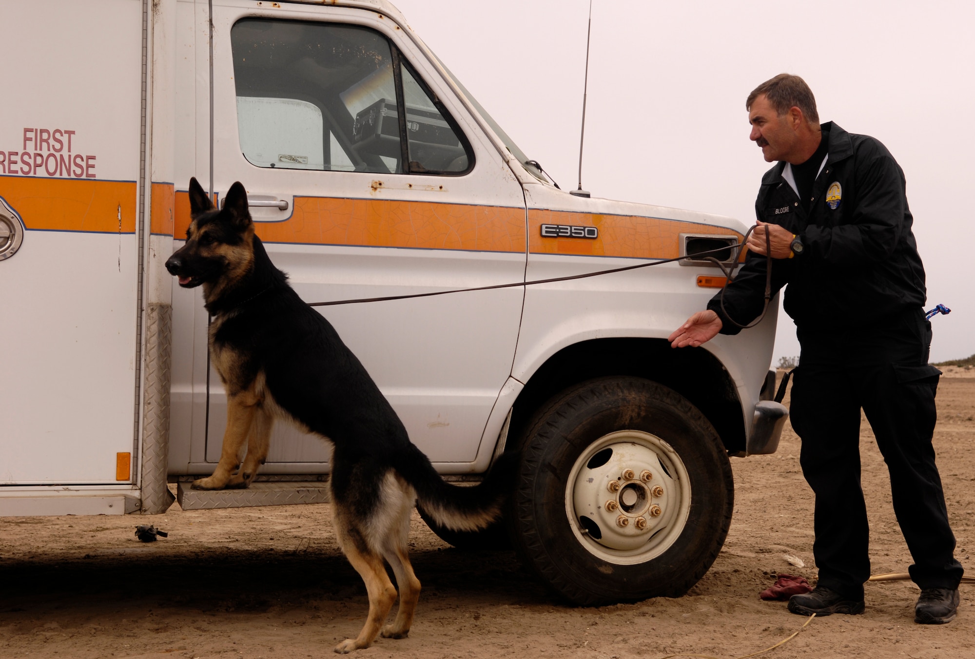 VANDENBERG AIR FORCE BASE, Calif. -- Finn McClafferty and his K-9, Max, from the Beverly Hills Police Department, search an ambulance for explosive ordnance on Nov. 6.  The ambulance was later demolished by 500 pounds of explosives during Federal Bureau of Investigations post-blast investigator training  Federal, state and local law enforcement officers involved in bomb crime-scene investigations participate in this one-week course which places an emphasis on the identification and collection of fragmented and mutilated bomb components. (U.S. Air Force photo/Airman 1st Class Christian Thomas)

